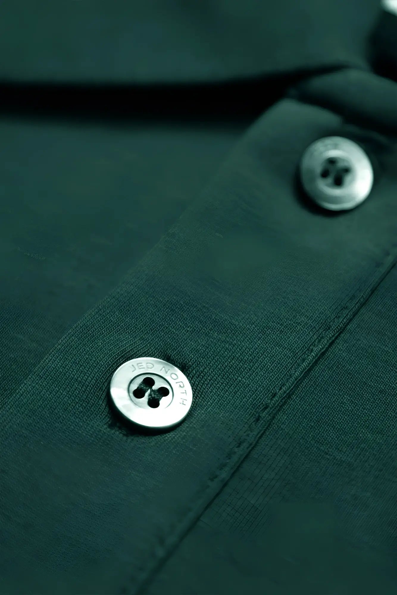 Silver button engraved with jes royal on muscle fit all-day polo t-shirt in evergreen dark green fabric