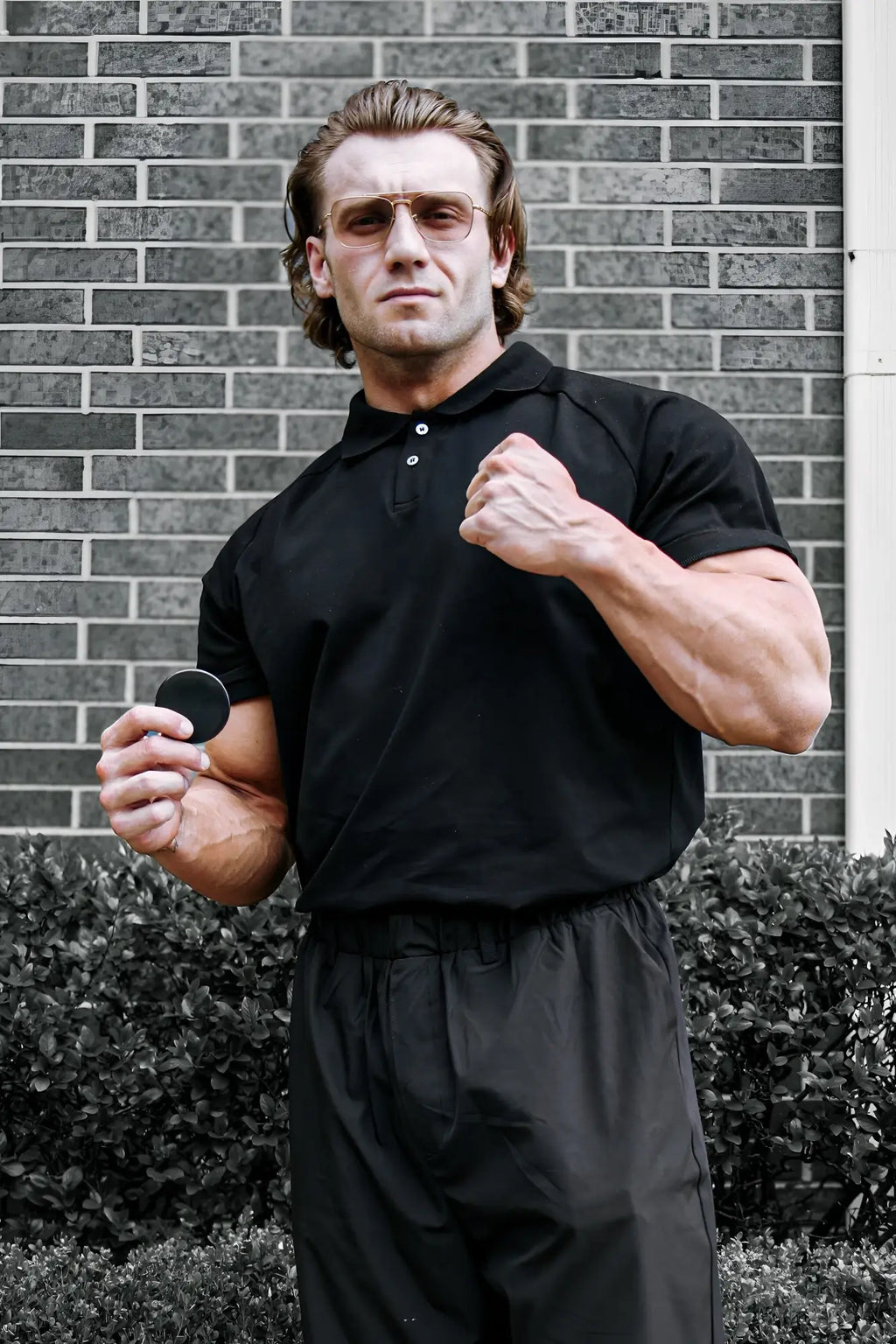 Black circular disc held in hand representing jed north muscle fit all-day polo t-shirt in onyx black color