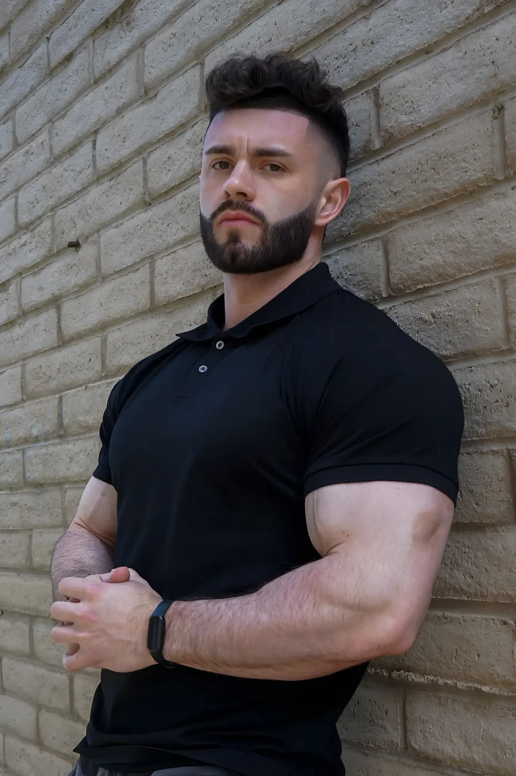 Black short-sleeved muscle fit polo shirt by Jed North with collar and button placket in onyx black color