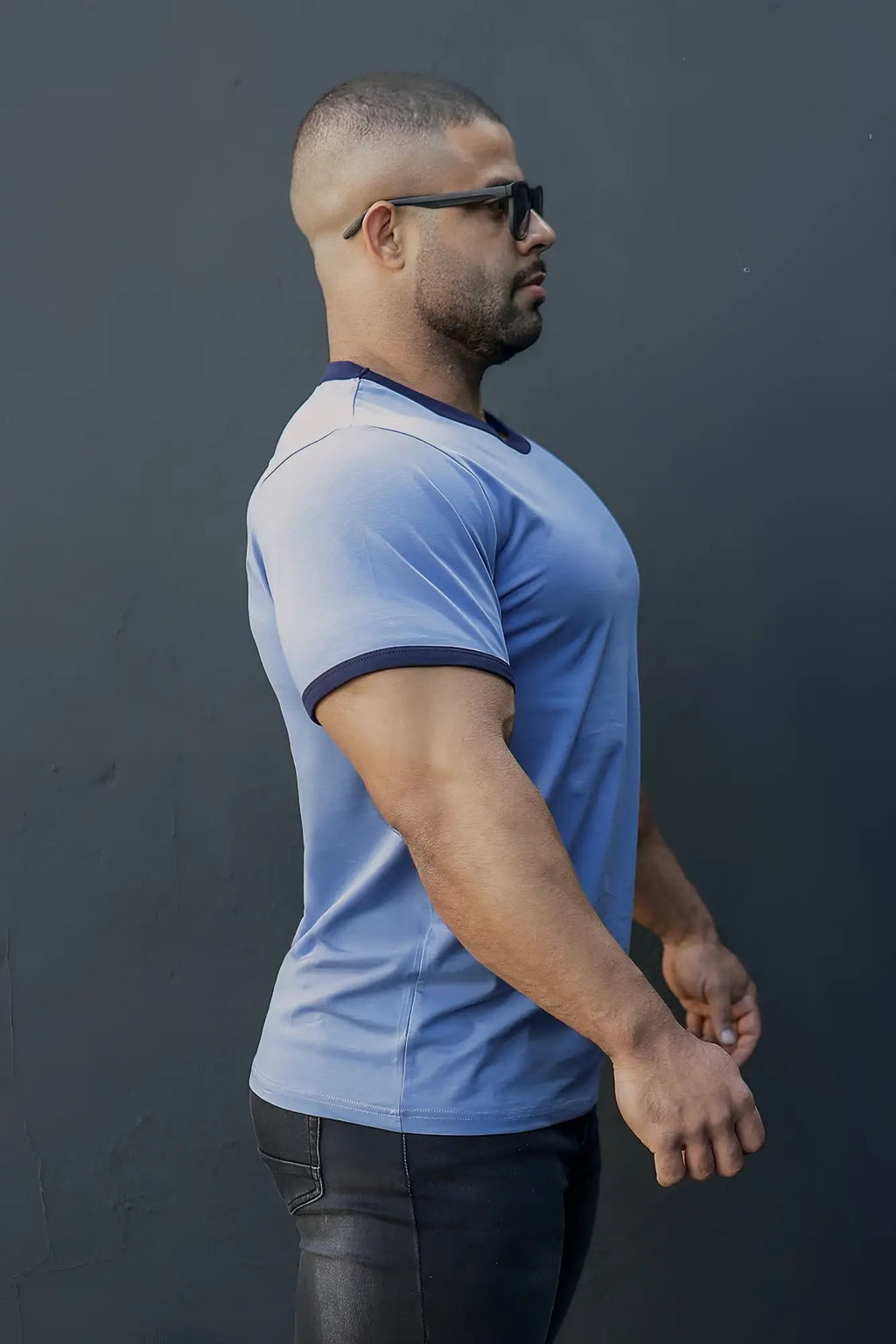 A man wearing a muscle-fit ringer t-shirt in electric blue with navy trim on collar and sleeve cuffs