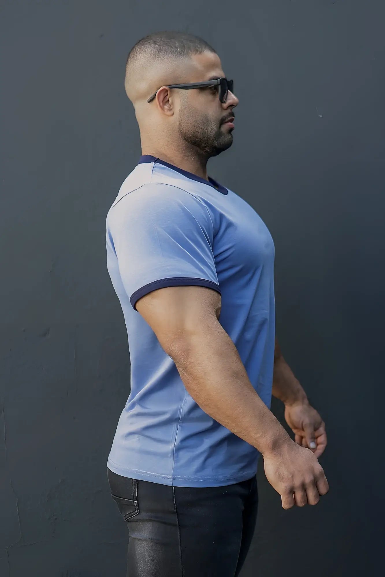 A man wearing a muscle-fit ringer t-shirt in electric blue with navy trim on collar and sleeve cuffs