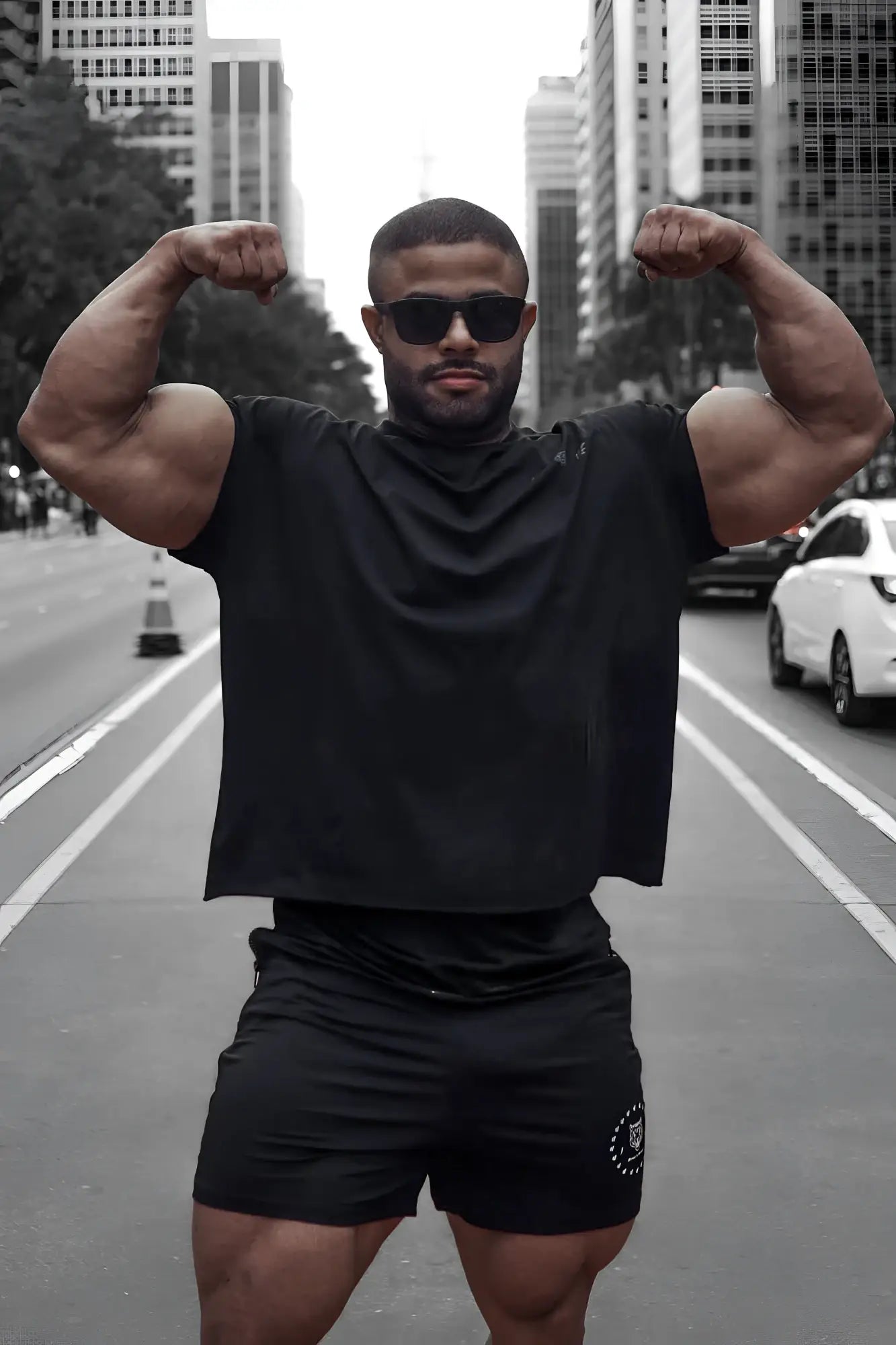 A black oversized raw-cut cropped tee with short sleeves and a small white logo on the lower left side