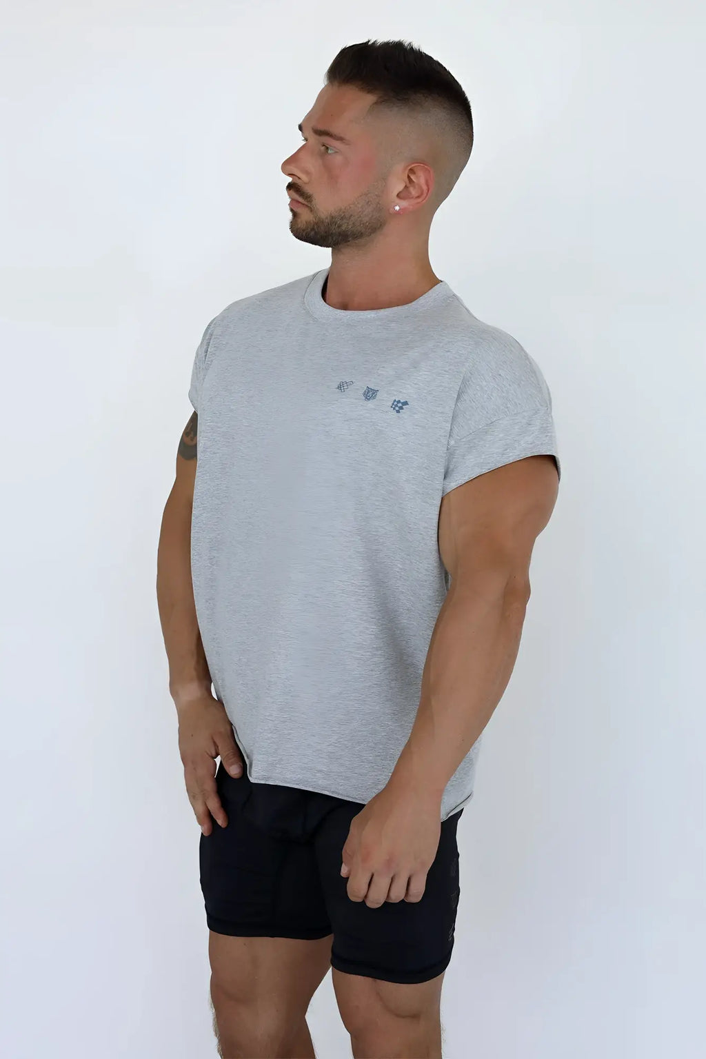 Gray heathered oversized raw cut cropped sleeveless t-shirt with small embroidered logo on the chest