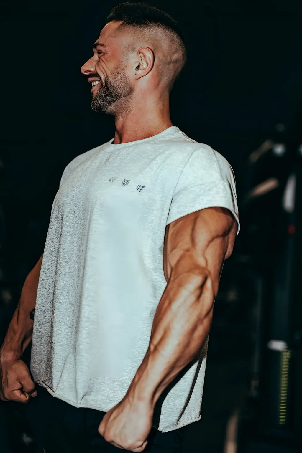 A heather gray oversized raw-cut cropped tee with short sleeves and a subtle chest logo made from soft fabric