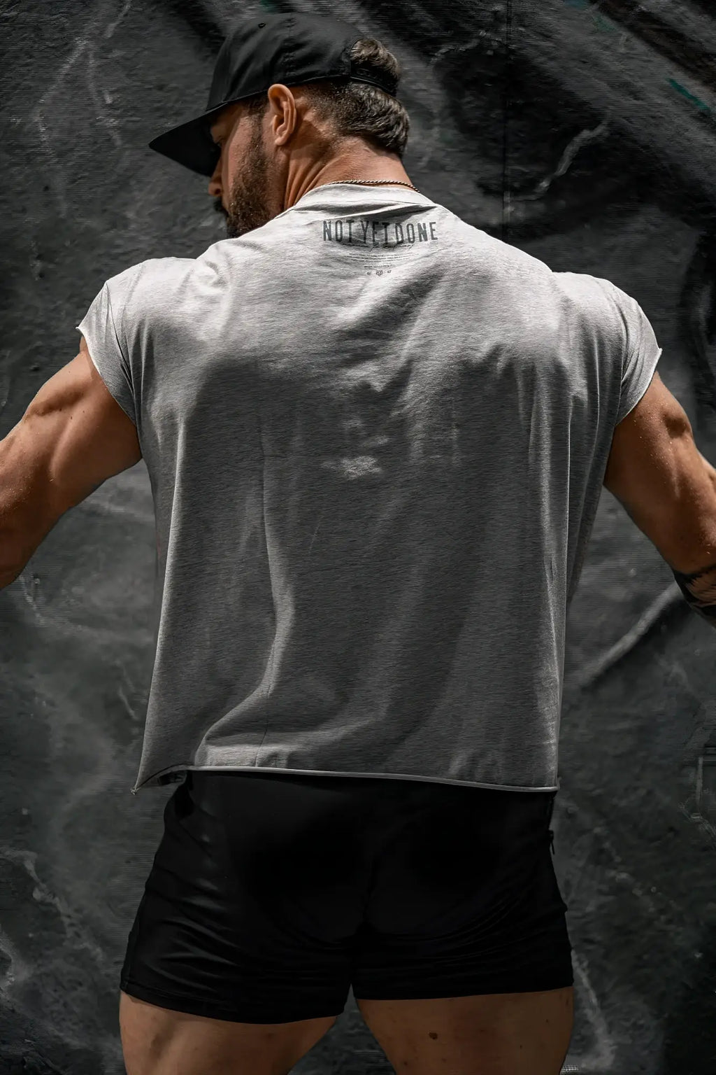 Back of oversized raw-cut cropped tee in heather gray sleeveless with not in loone printed on the back