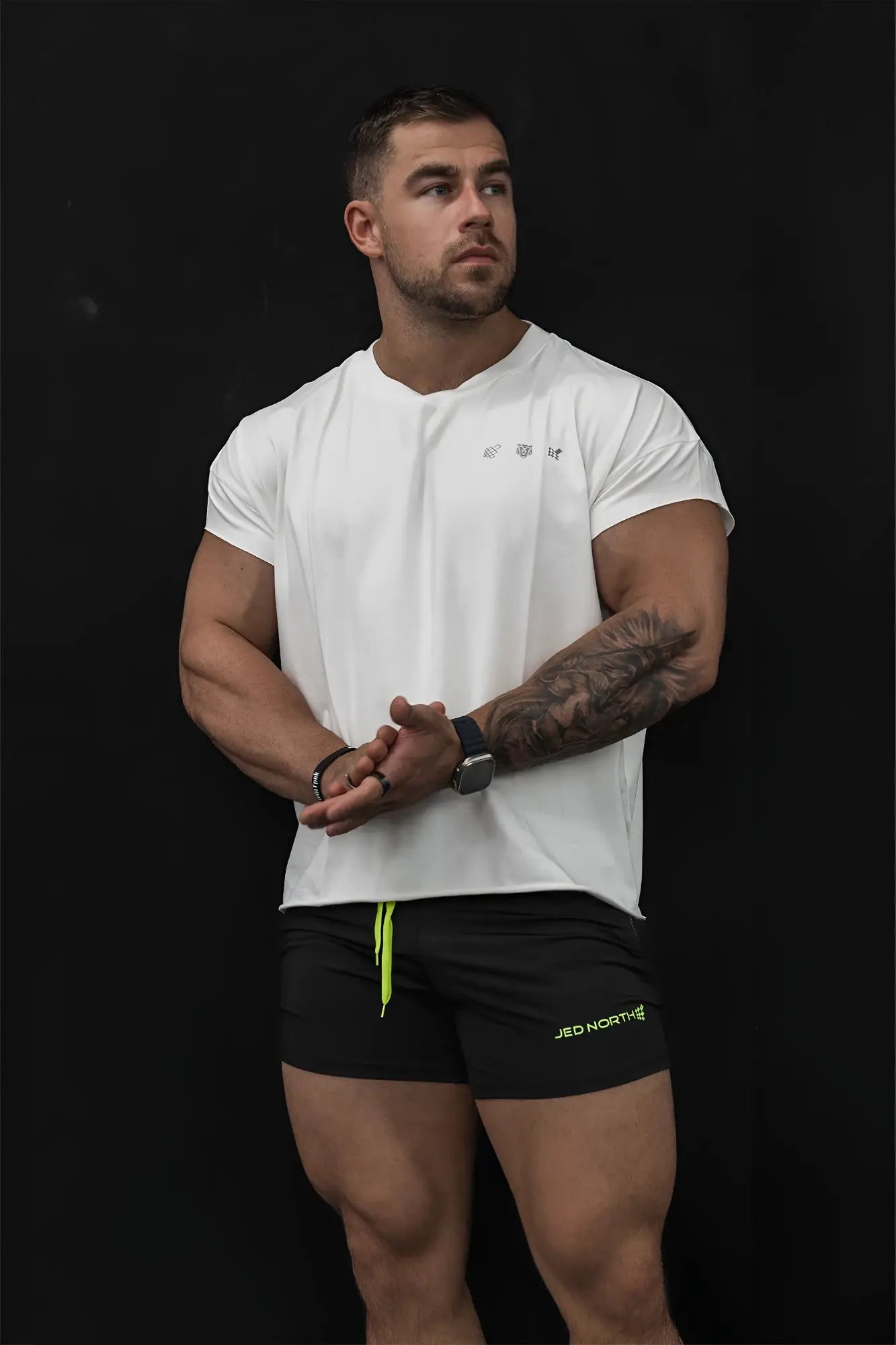 White oversized raw-cut cropped athletic tee with short sleeves and subtle logo on the chest