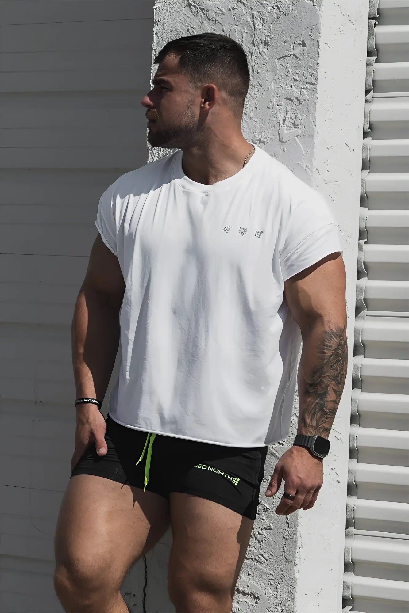 White oversized raw cut cropped tee with short sleeves and subtle gray logo on the chest for athletic wear