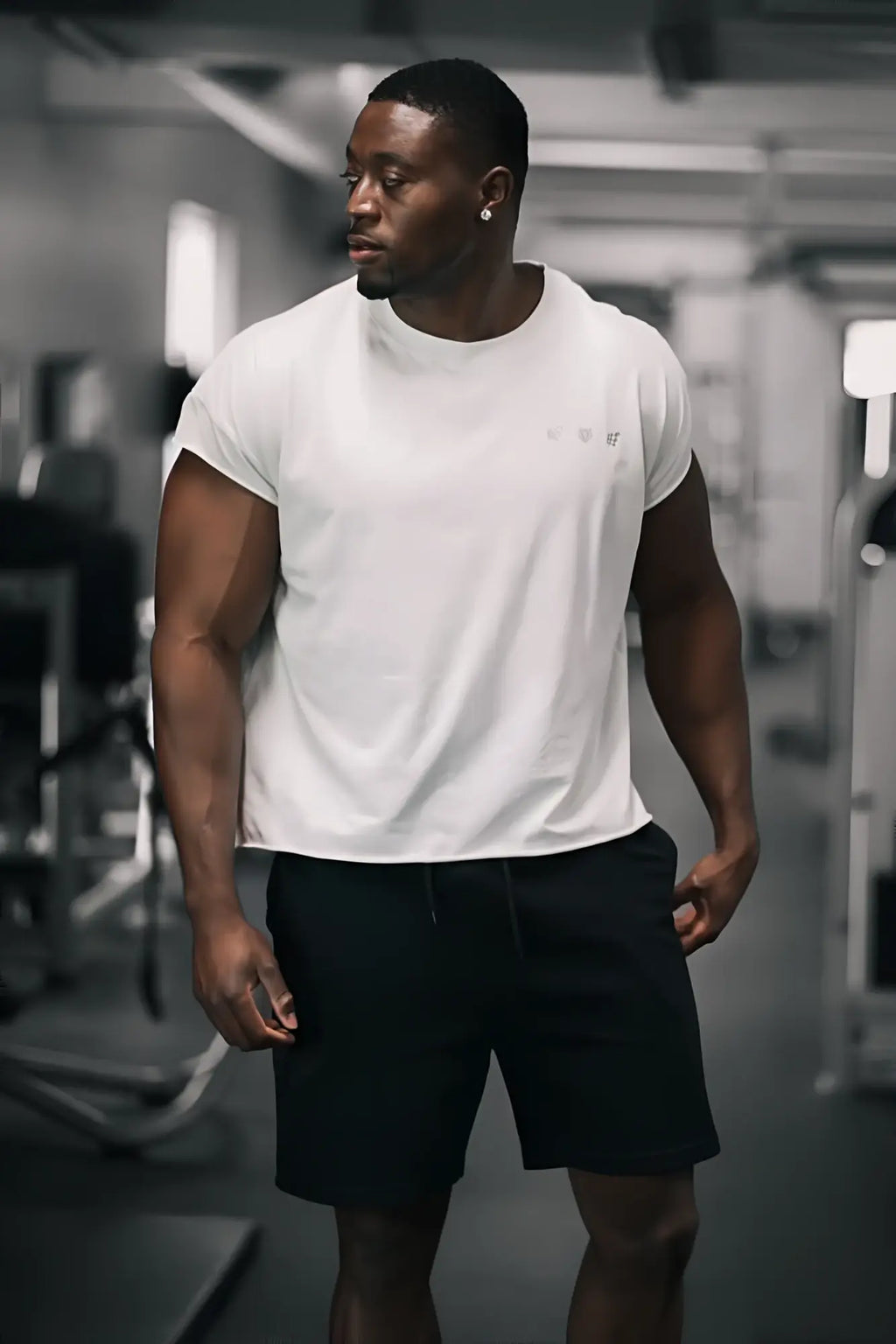 White oversized raw-cut cropped tee with short sleeves and subtle logo on chest made from soft cotton