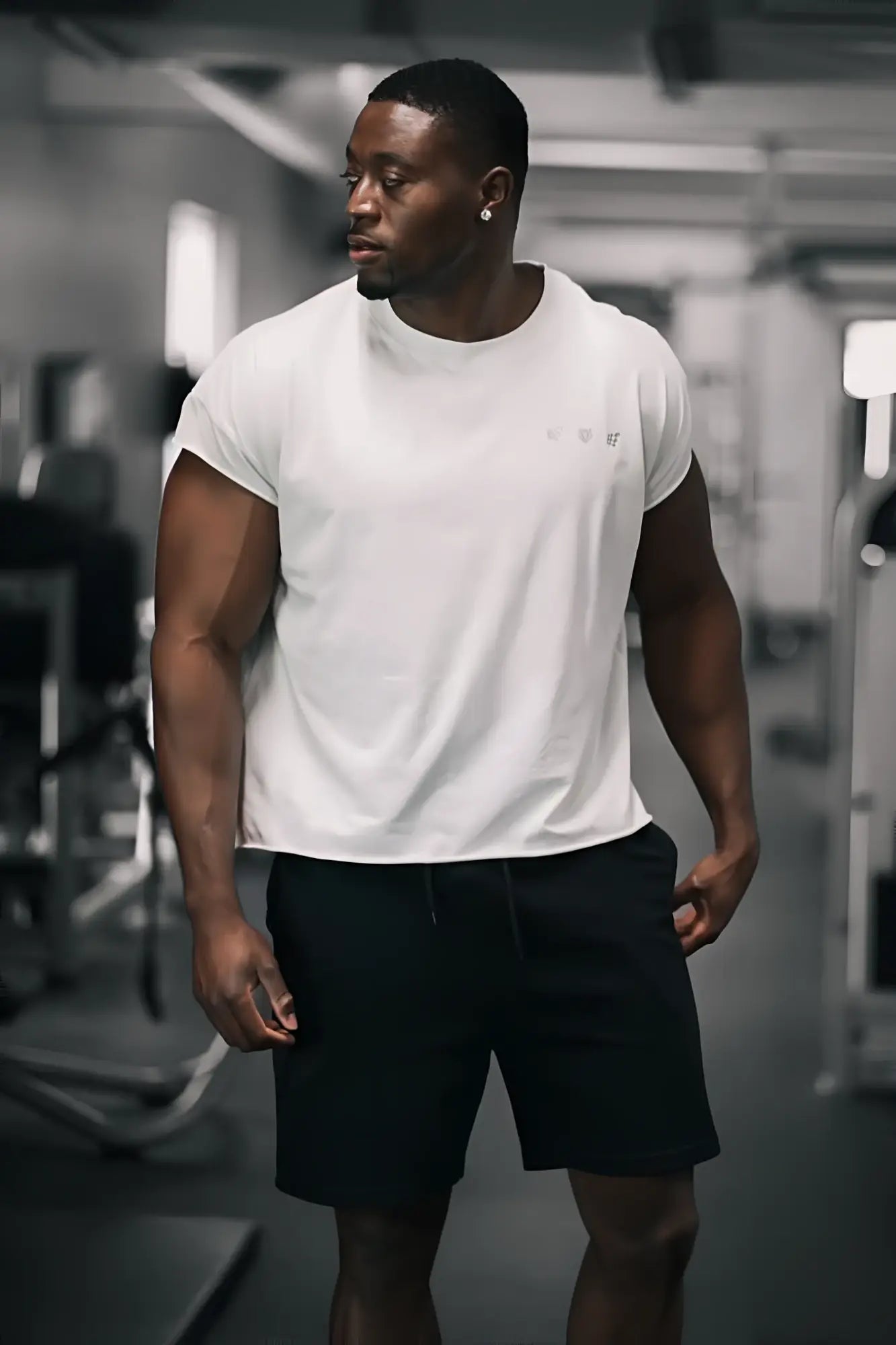White oversized raw-cut cropped tee with short sleeves and subtle logo on chest made from soft cotton