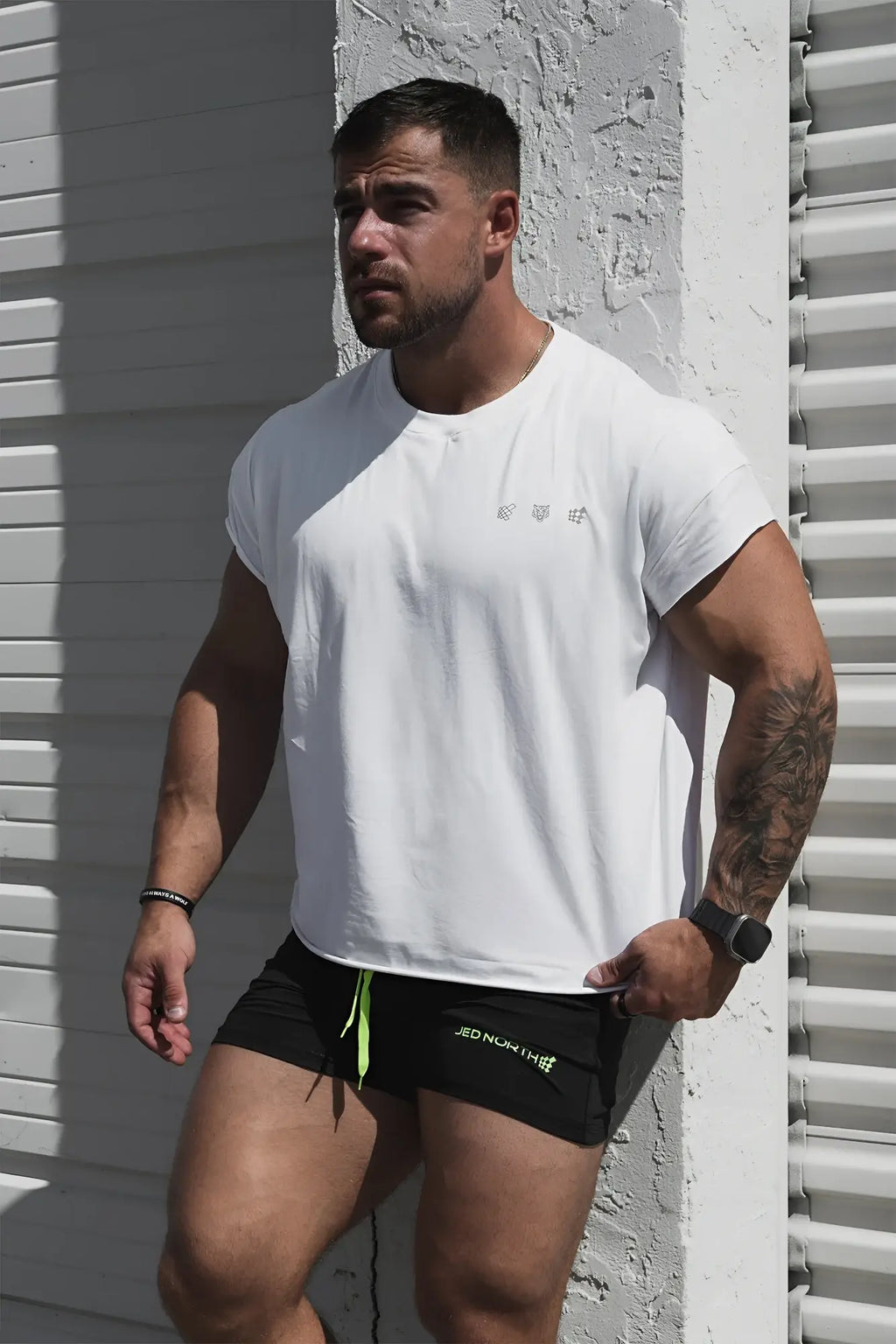 White oversized raw-cut cropped t-shirt with short sleeves and subtle gray logo on the chest in soft cotton fabric