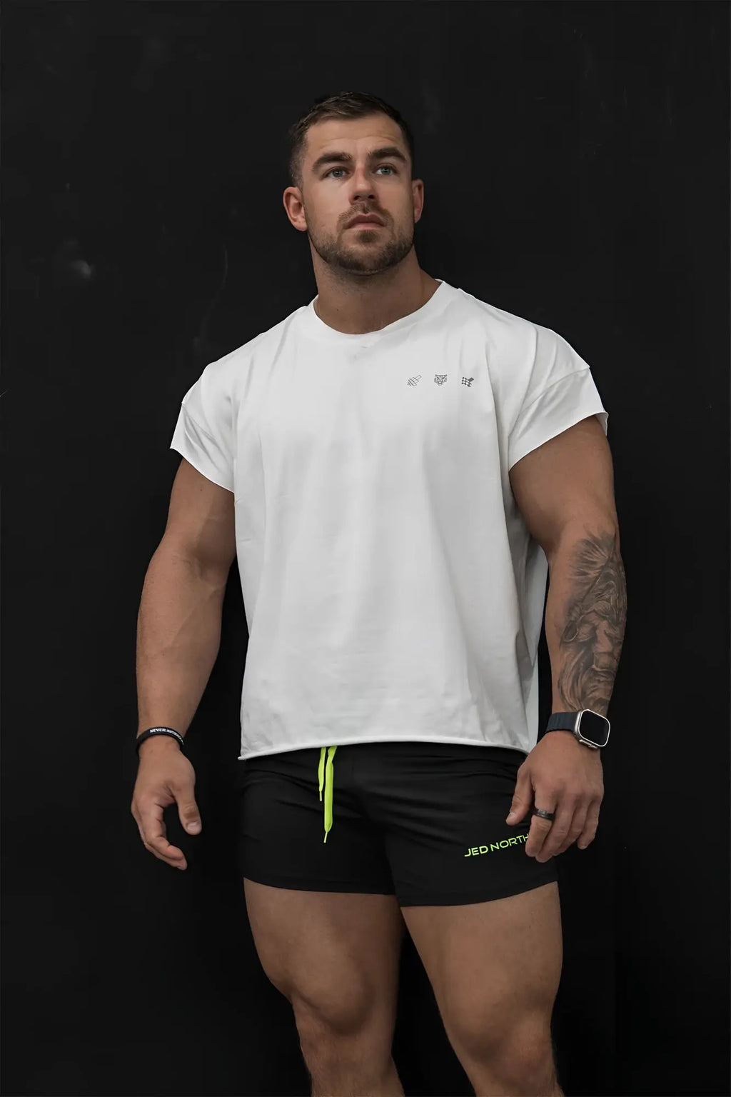 Oversized raw-cut cropped white tee with short sleeves neon green side trim and small collar logo