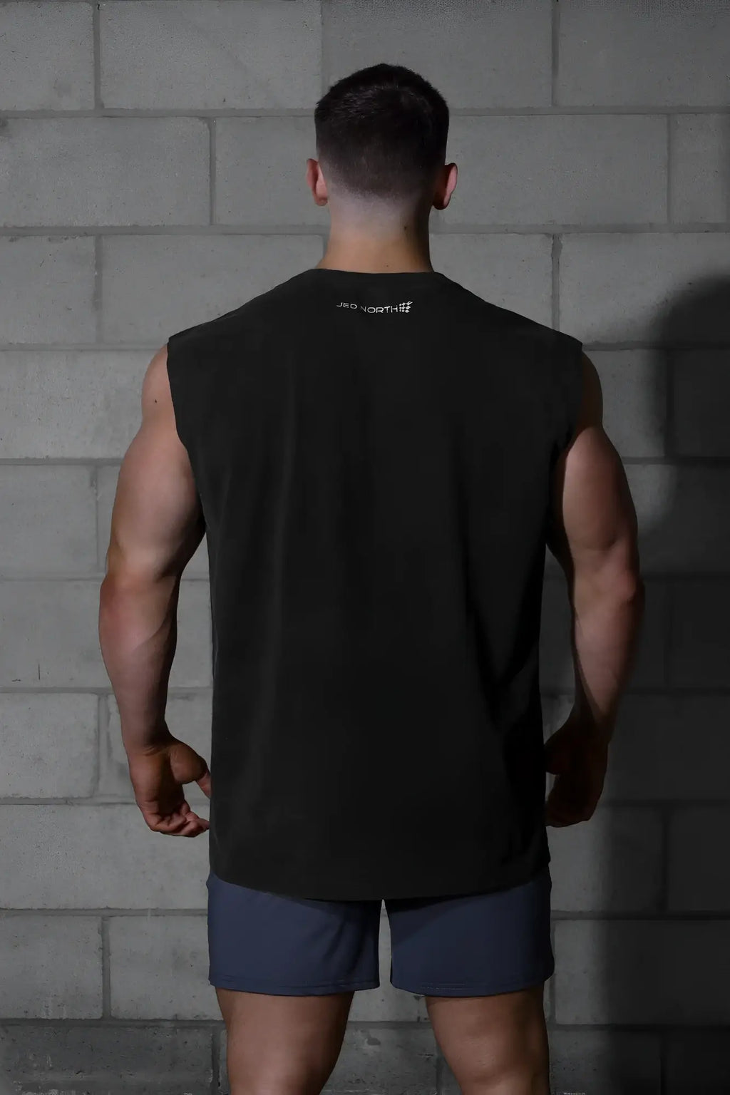 Black sleeveless athletic tank top with a small white logo at the neckline from jed north oversized washed collection