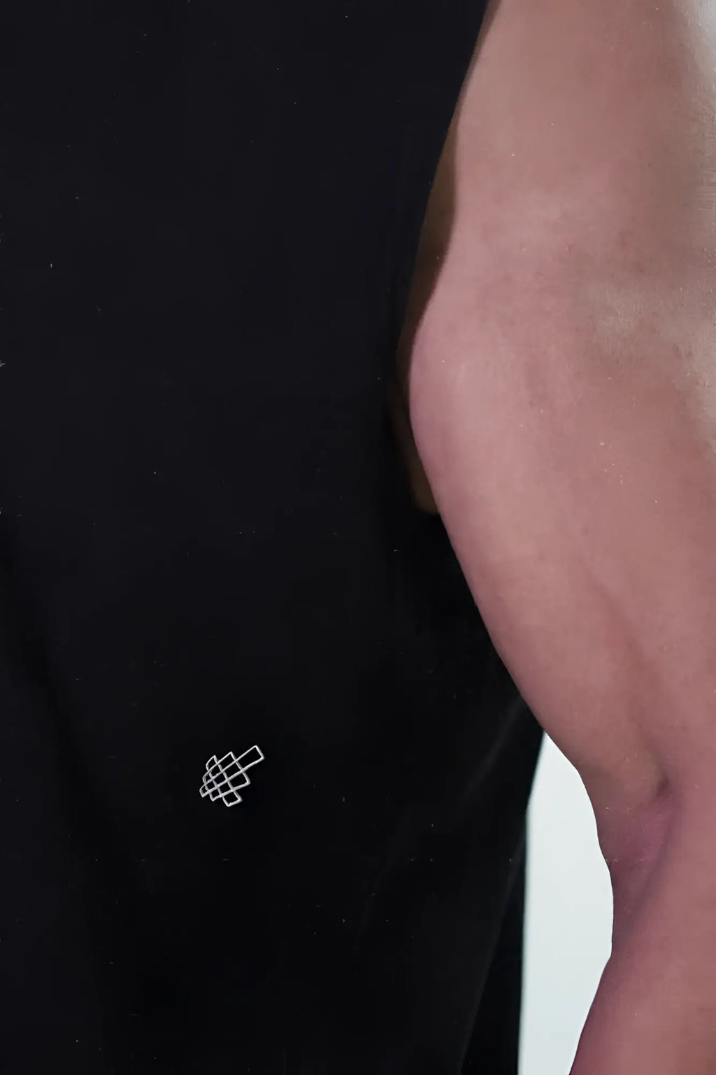 Jed North oversized washed sleeveless t-shirt in washed black with a small white geometric logo embroidered on lower left side