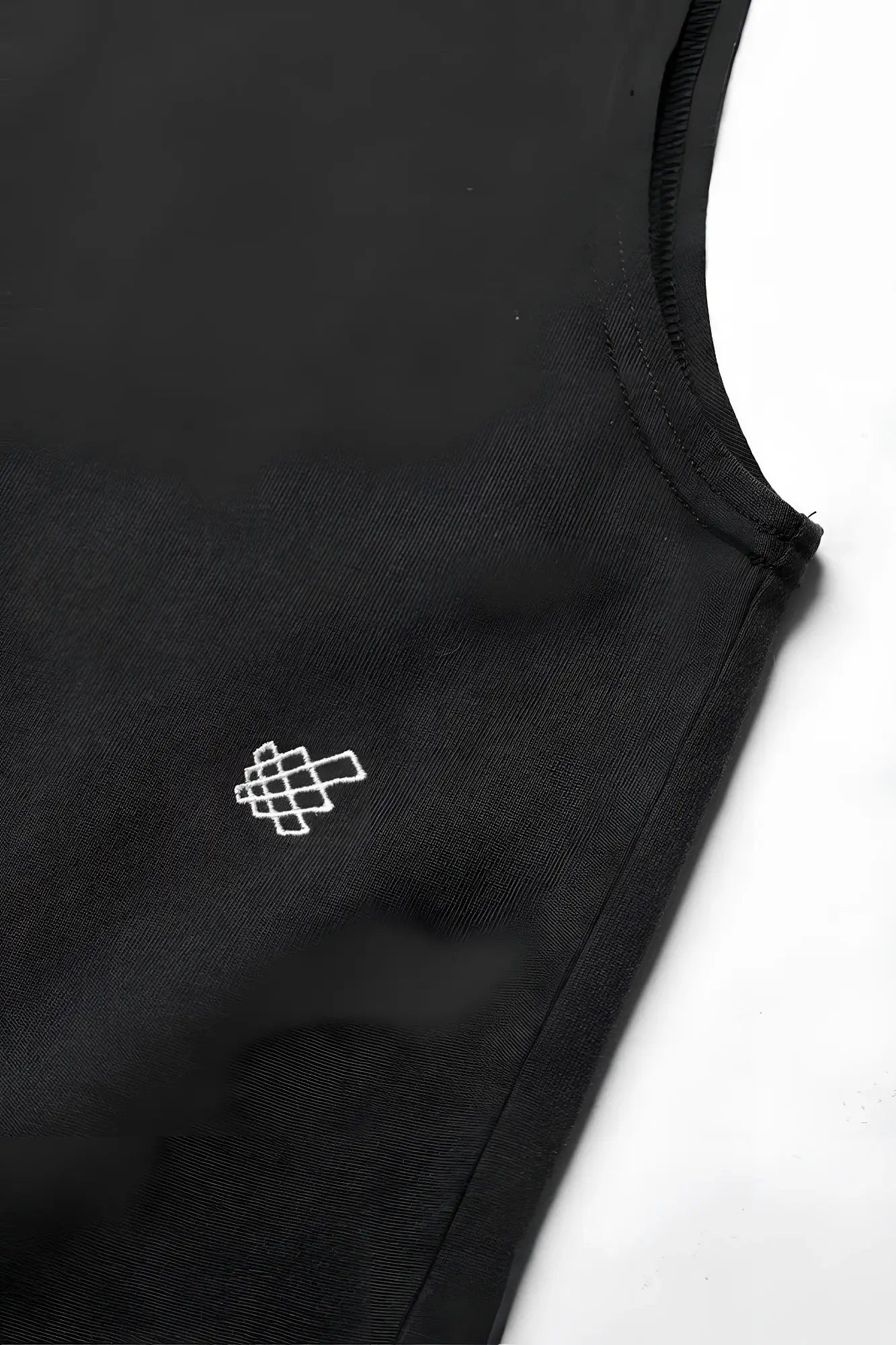 Jed North oversized washed sleeveless t-shirt in washed black with a small white geometric logo embroidered on the chest