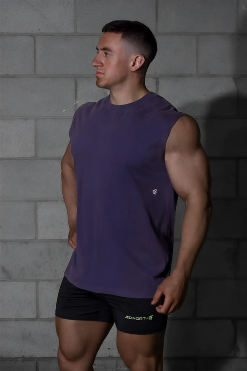 Purple sleeveless muscle tank top with small white logo on left chest in Jed North oversized washed sleeveless t-shirt style