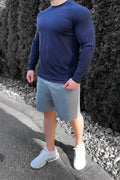 Navy blue long-sleeved athletic shirt made of breathable fabric paired with jed north performance air-tech gray shorts