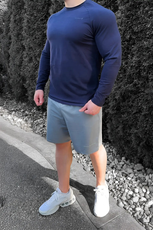 Navy blue long-sleeved athletic shirt made of breathable fabric paired with jed north performance air-tech gray shorts