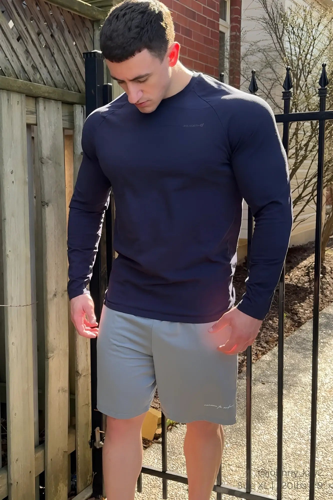 Navy blue long-sleeved athletic shirt shown from the back paired with gray jed north performance air-tech athletic shorts
