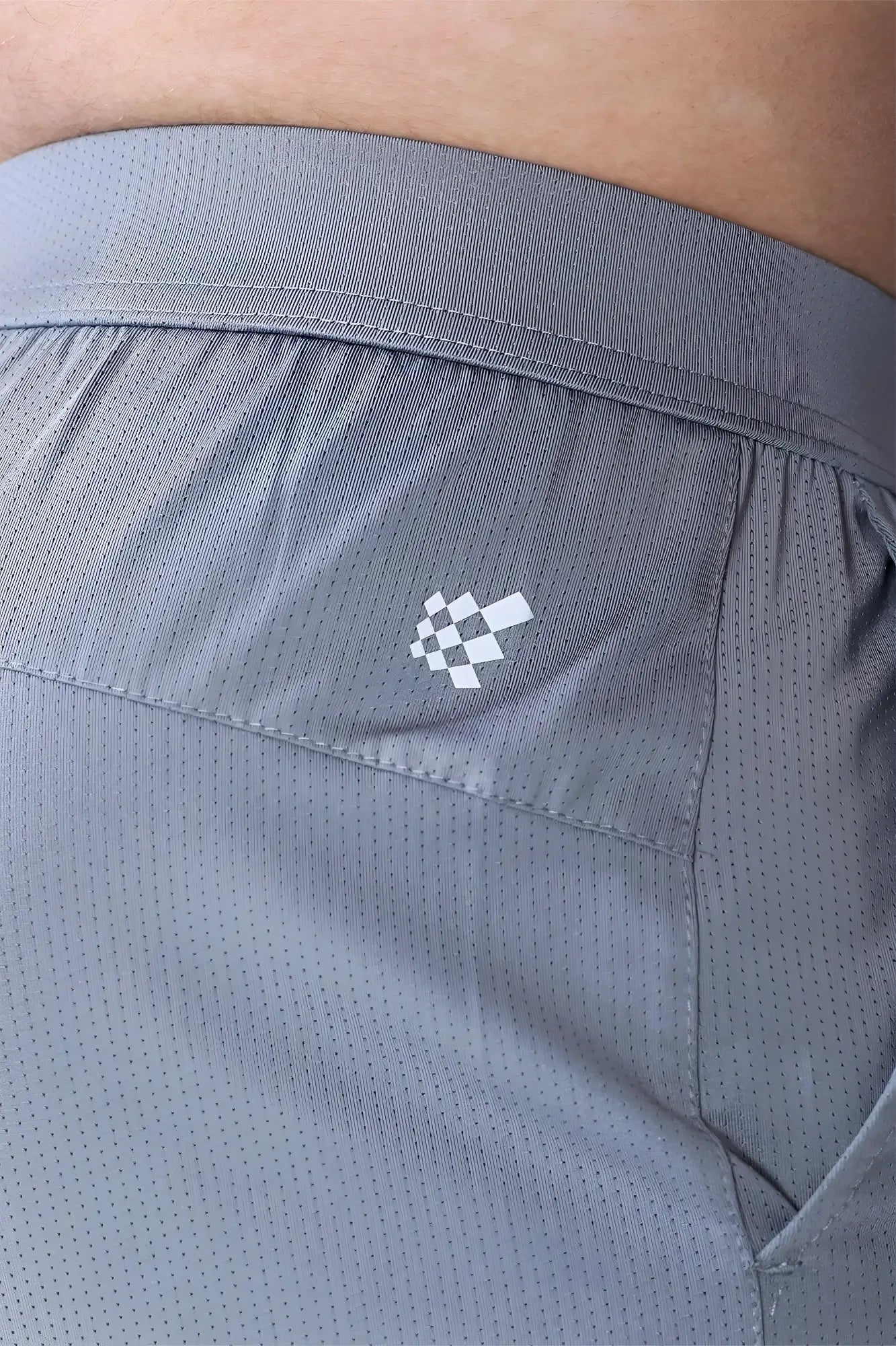 Gray jed north performance air-tech athletic shorts with subtle perforated texture and white checkered logo on side seam
