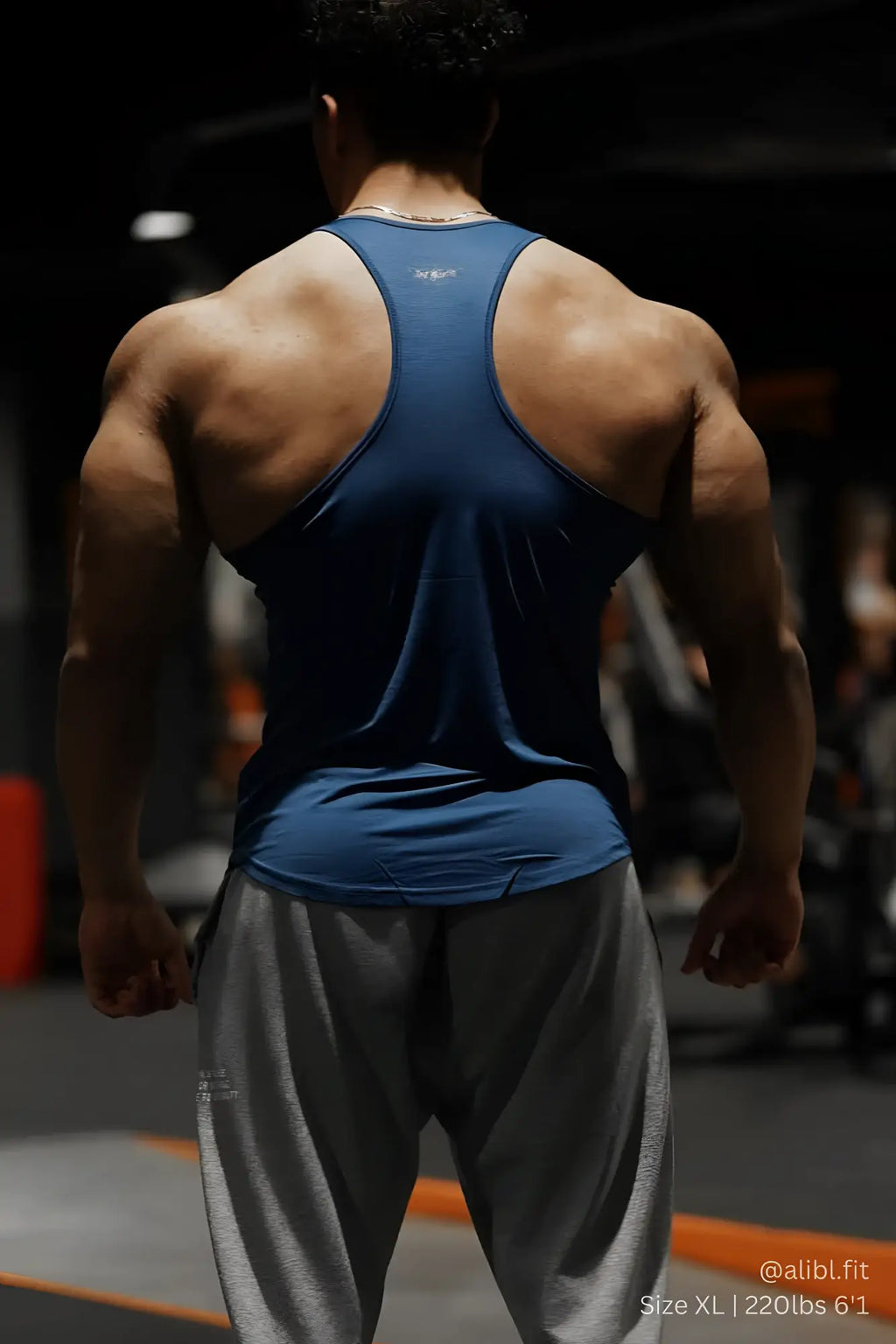 Back view of jed north performance max bodybuilding stringer in denim blue with racerback design and logo on upper back
