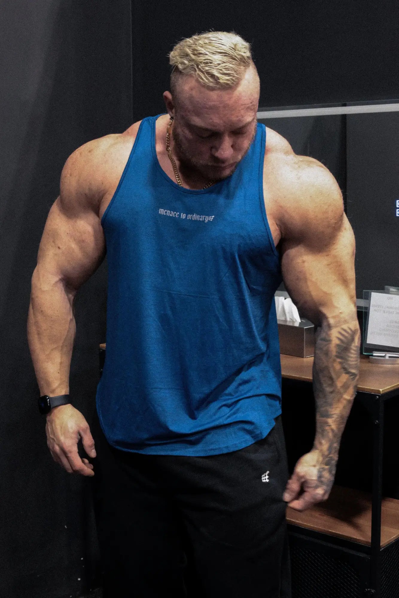 Blue muscle tank top with white text across the chest made of performance fabric for bodybuilding by jed north