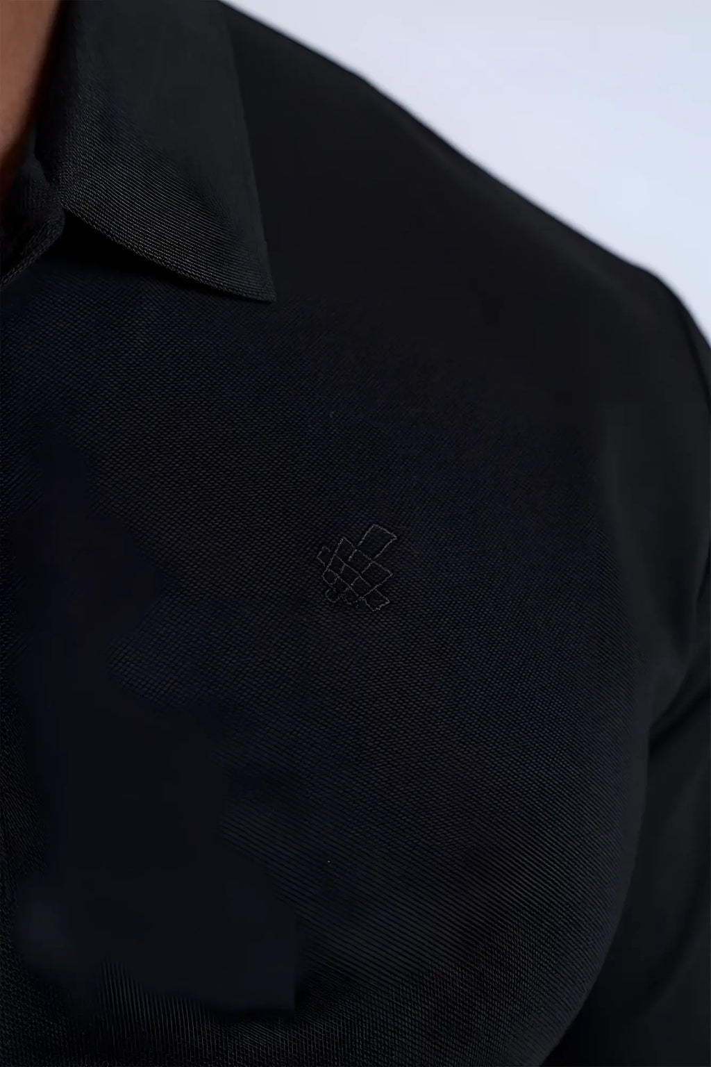 Black textured polo button-up longsleeve shirt with a subtle embroidered logo on the chest for casual wear