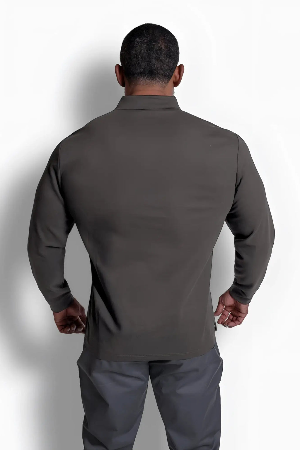 Dark gray long-sleeved performance shirt with tailored fit and subtle seam detailing in polo button-up style