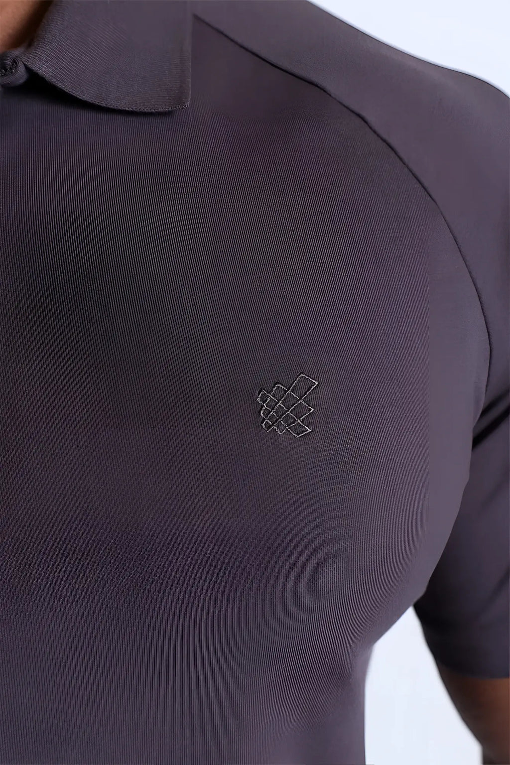 Dark gray premium muscle-fit polo tee with zipper textured fabric and subtle geometric logo embroidered on the chest