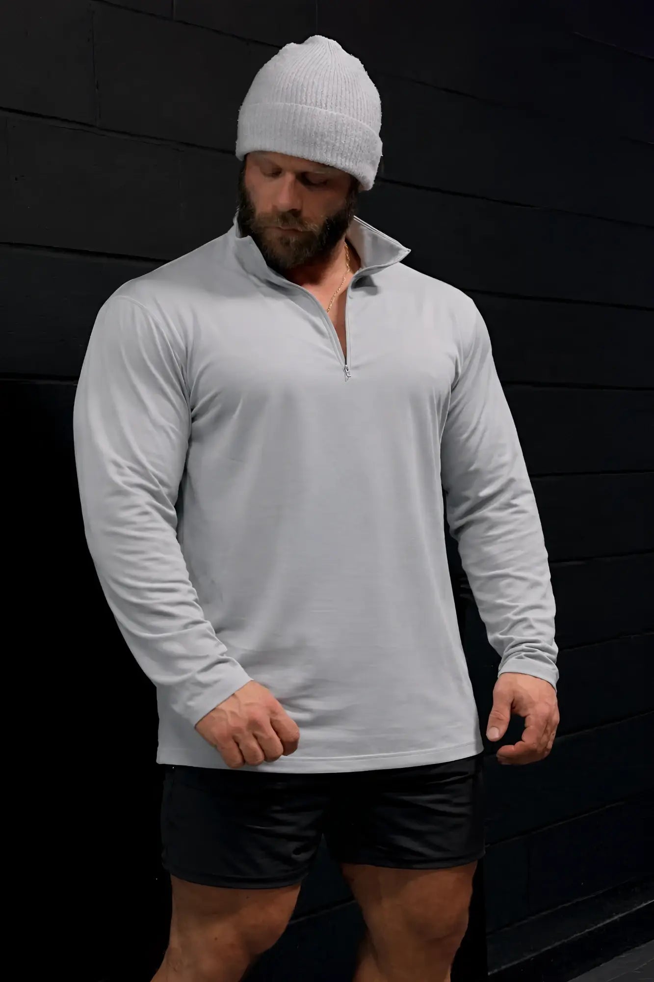 A man wearing a heather gray quarter-zip training long sleeve shirt with ribbed cuffs and collar