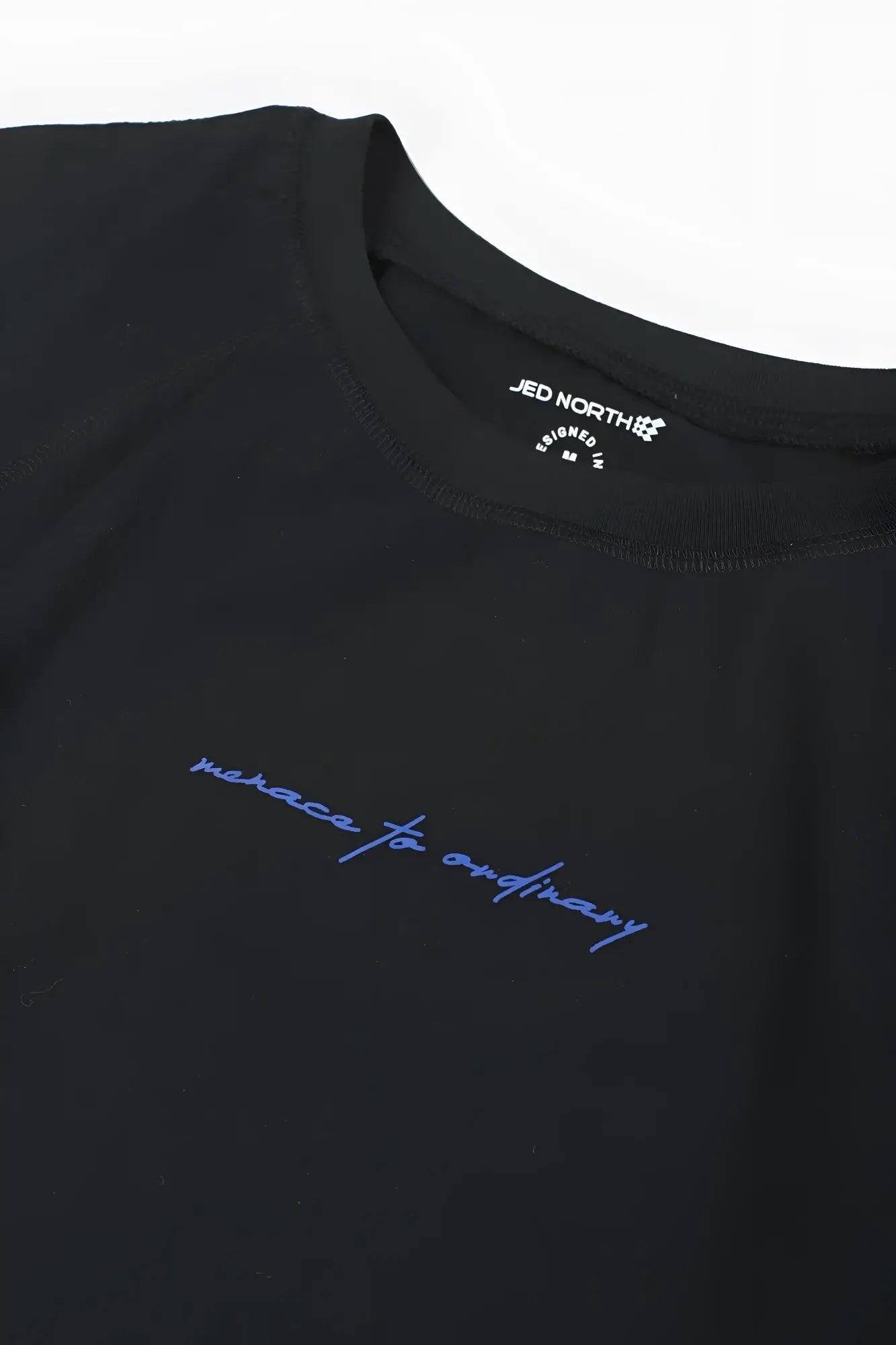 Black cotton raglan sleeveless muscle tank with blue embroidered script and jed north brand tag in the collar