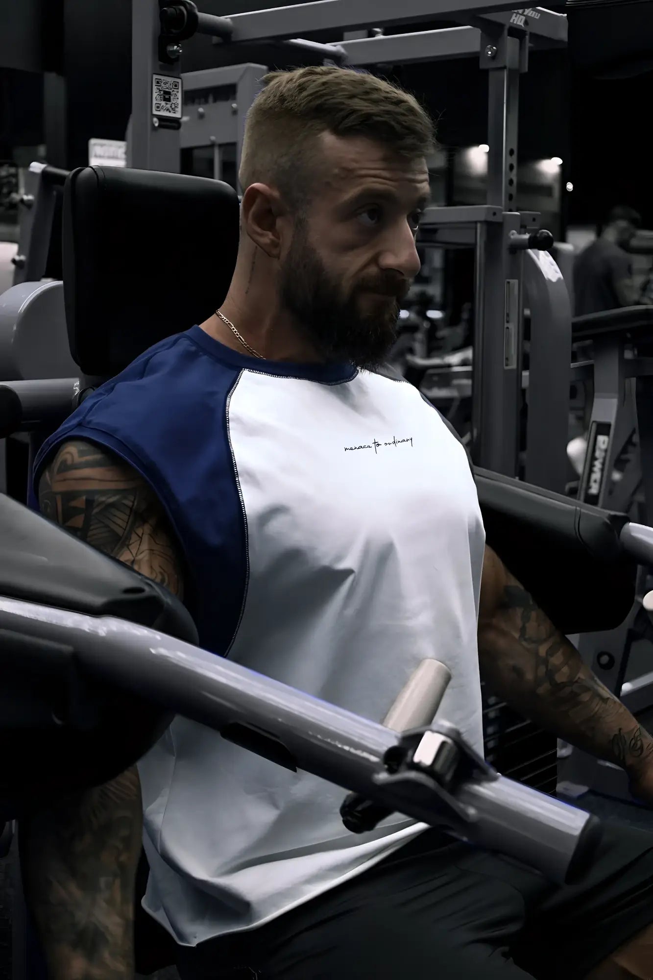 Navy raglan sleeveless muscle tank with blue and white color blocking and small embroidered logo on the chest