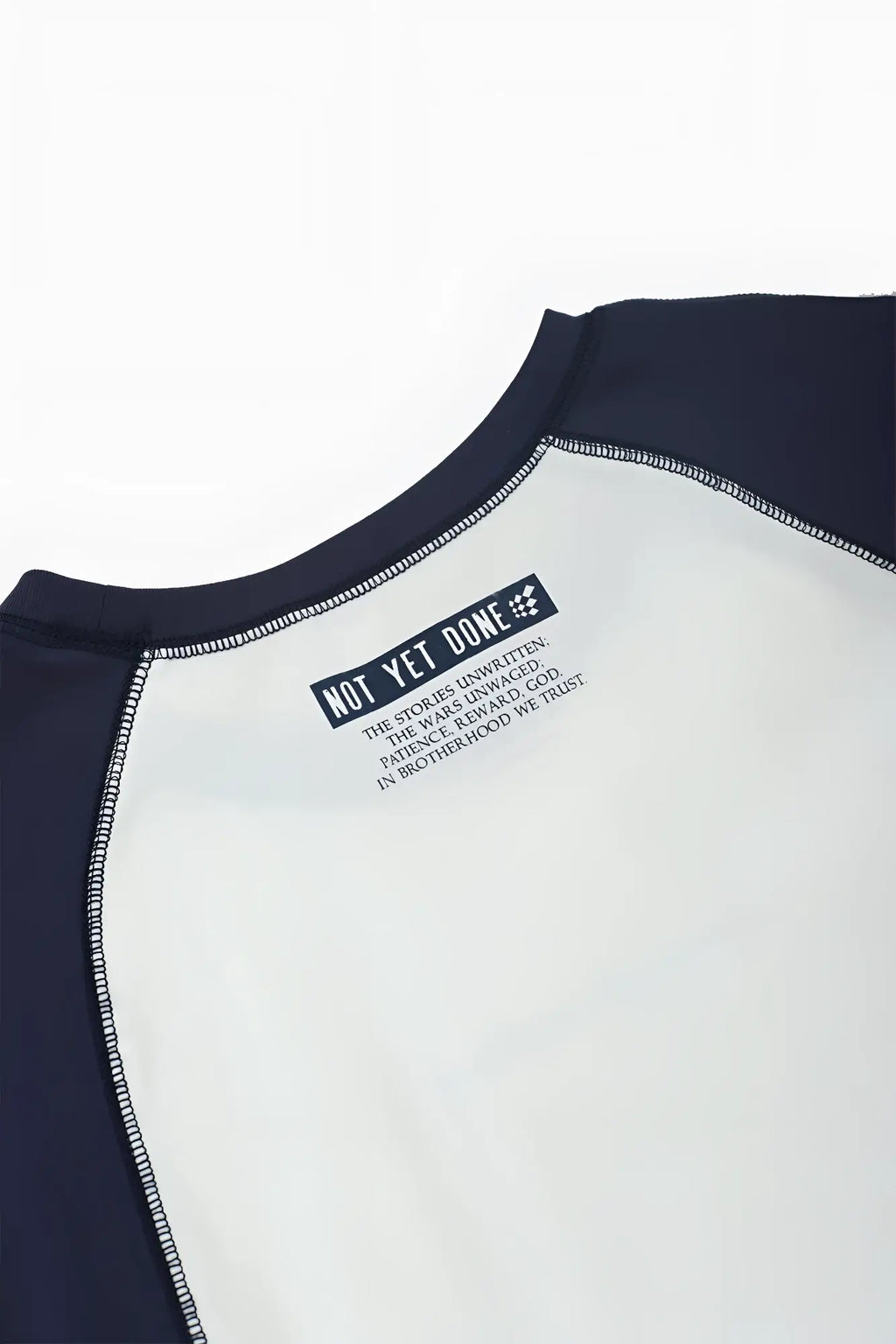 Navy and white raglan sleeveless muscle tank with a black label reading not yet done on the back side
