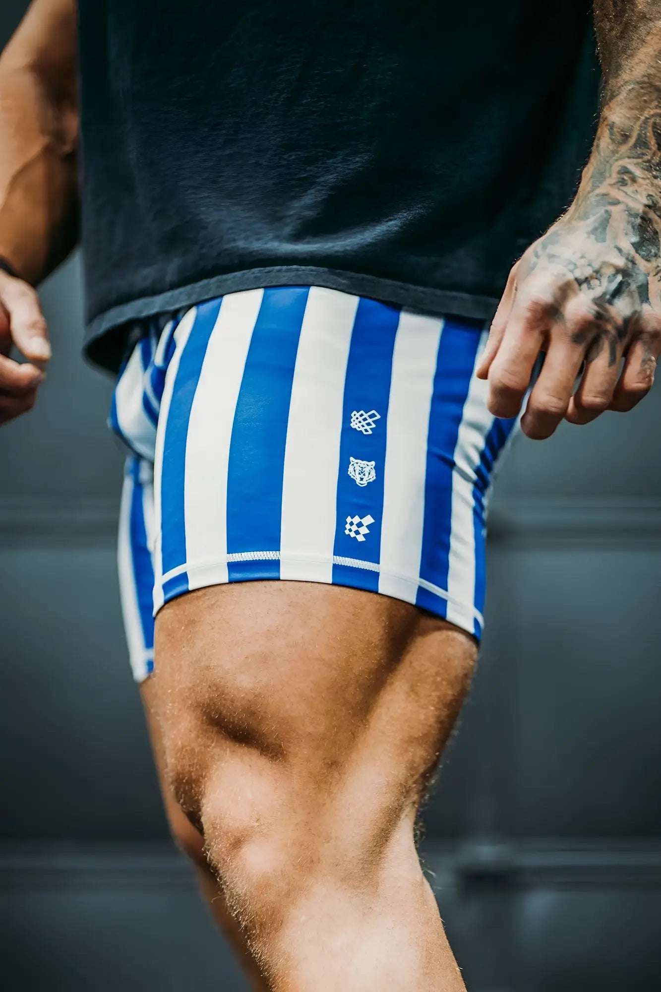 Retro bodybuilding shorts in blue and white vertical stripes with subtle side logo detail for athletic use