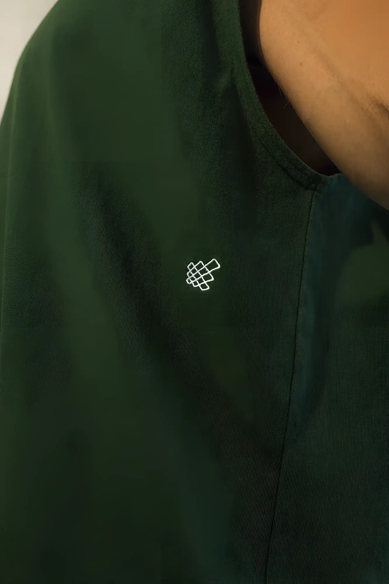 Dark green cotton retro oversized muscle tee with small white embroidered geometric logo on the chest