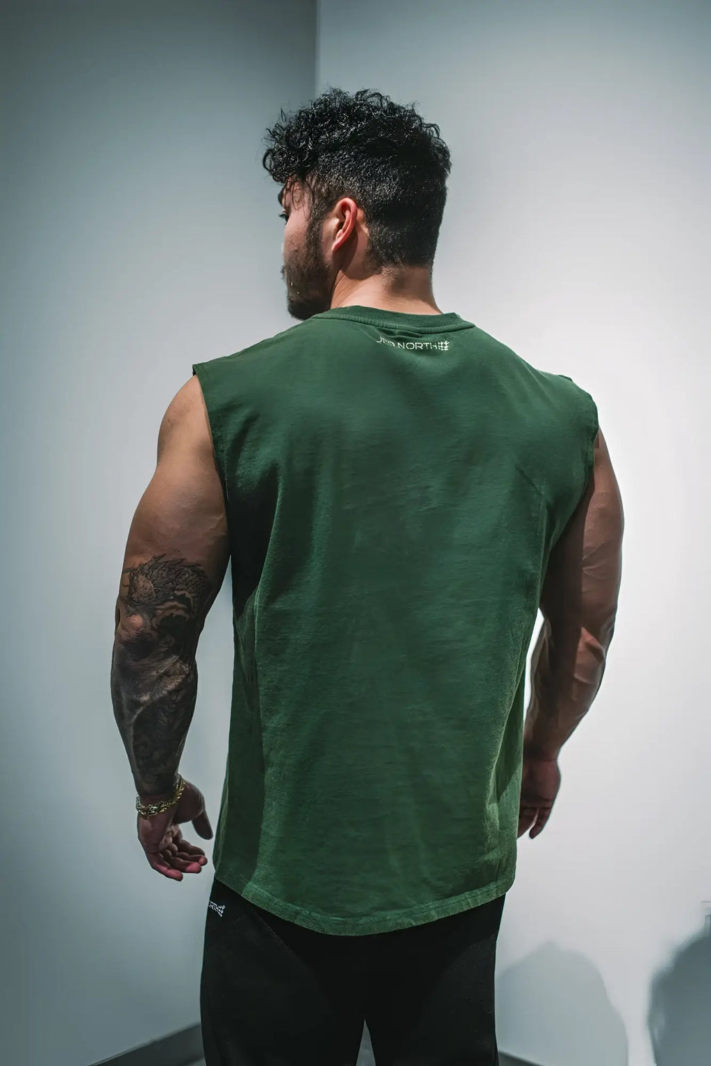Retro oversized muscle tee forest green sleeveless cotton tank top with subtle faded texture and small white logo