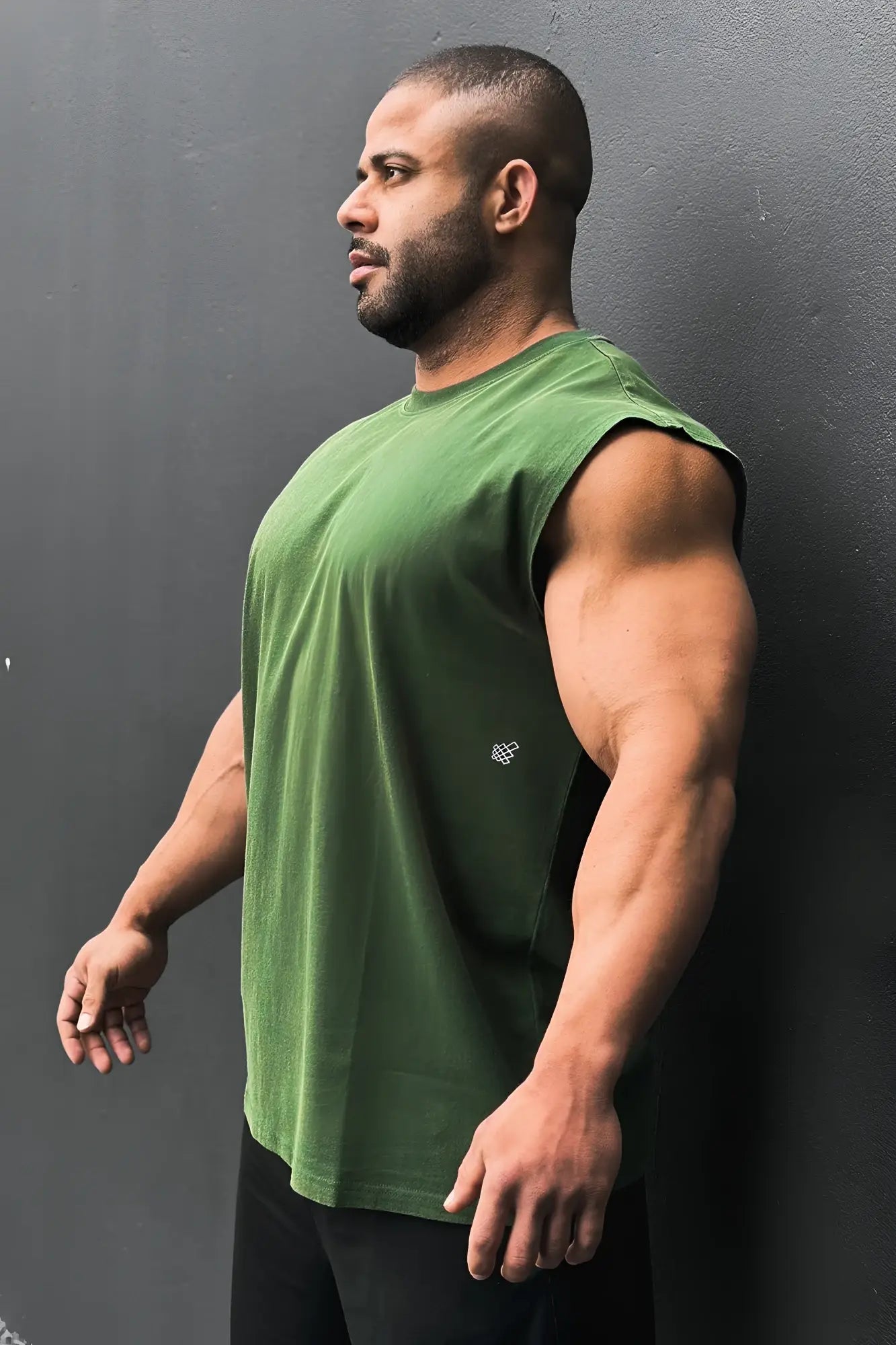 A forest green retro oversized muscle tee with a sleeveless design and small white logo on the left chest