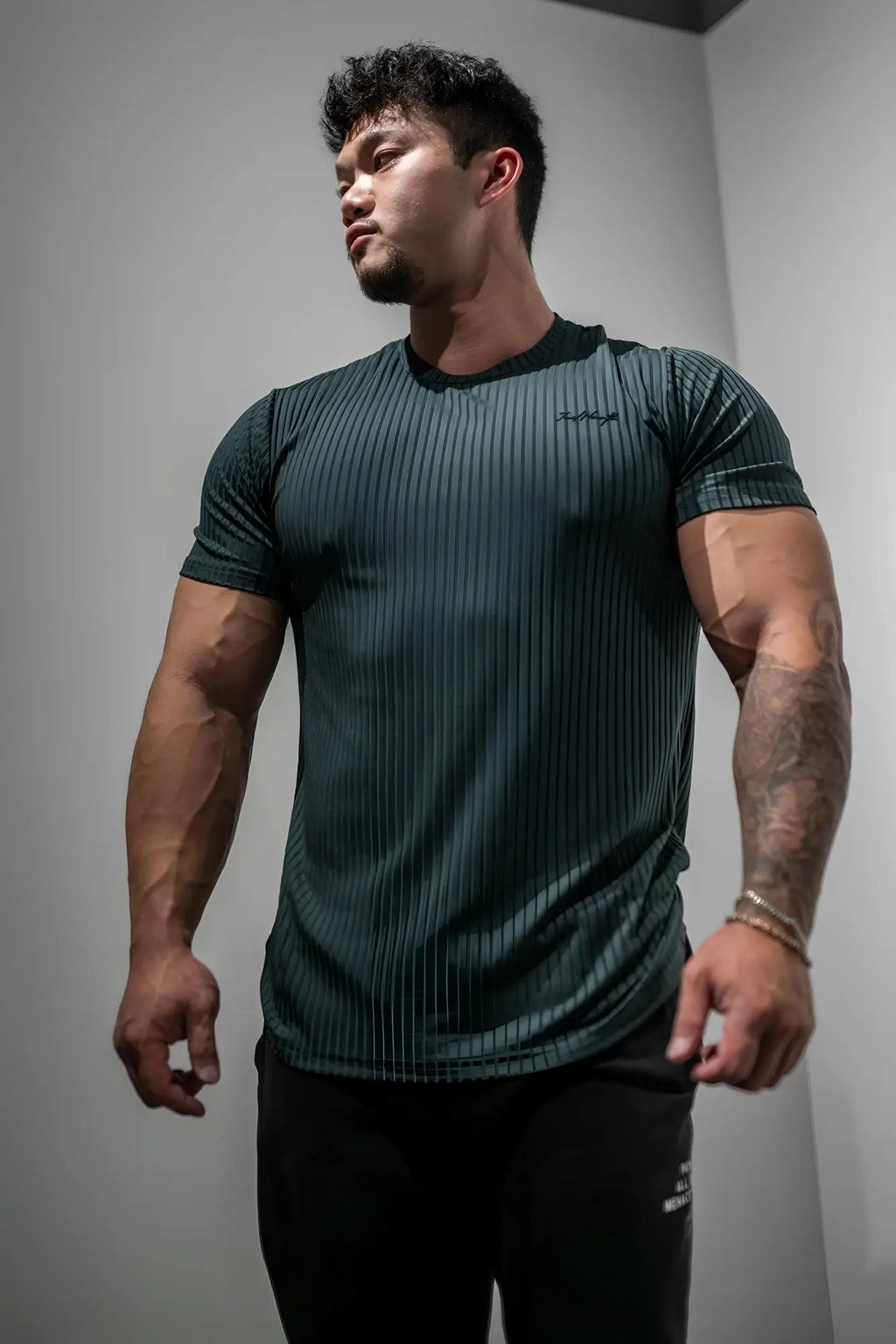 Dark green ribbed short-sleeve athletic tee with subtle textured pattern from jed north in forest green