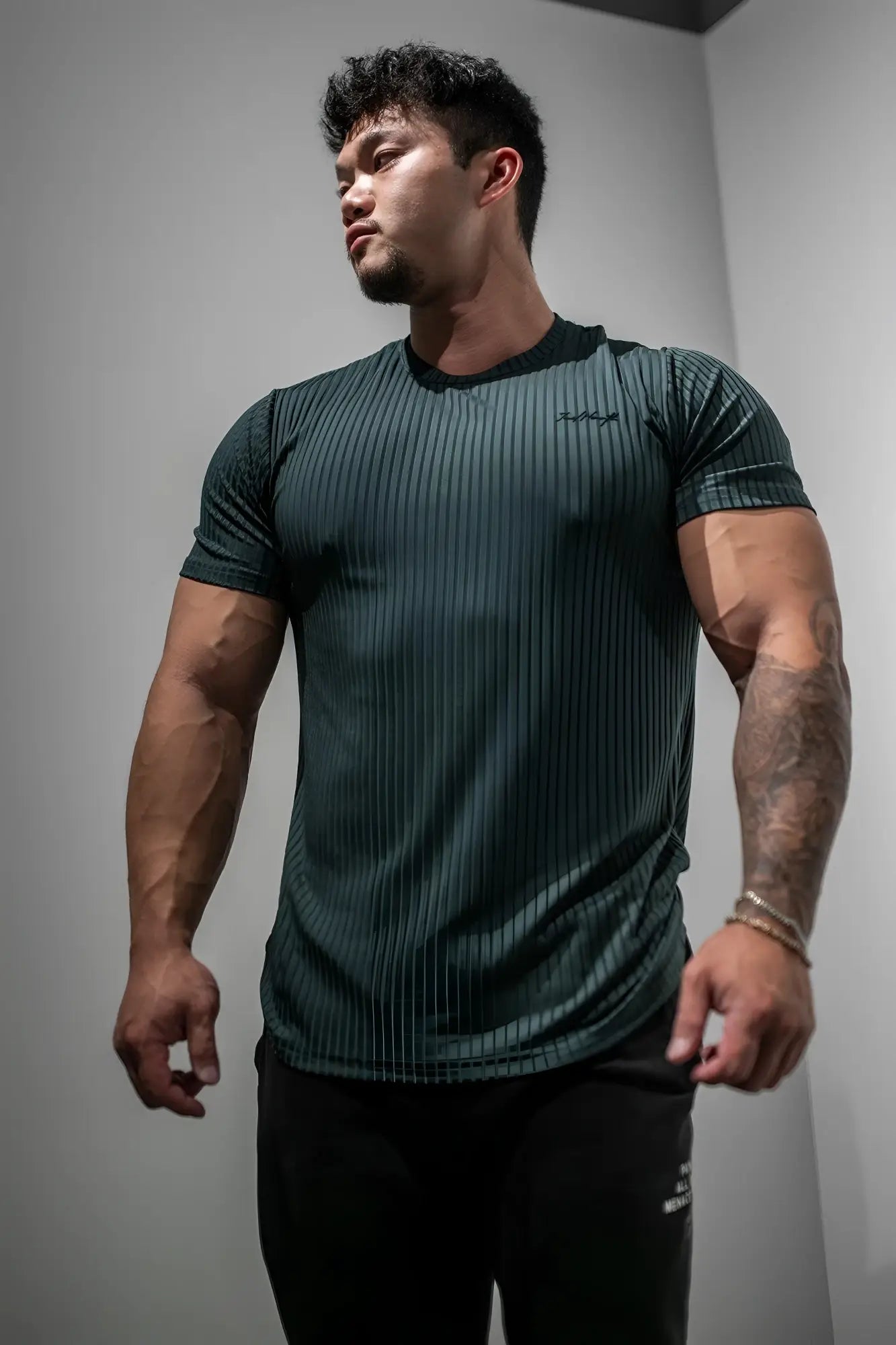 Dark green ribbed short-sleeve athletic tee with subtle textured pattern from jed north in forest green