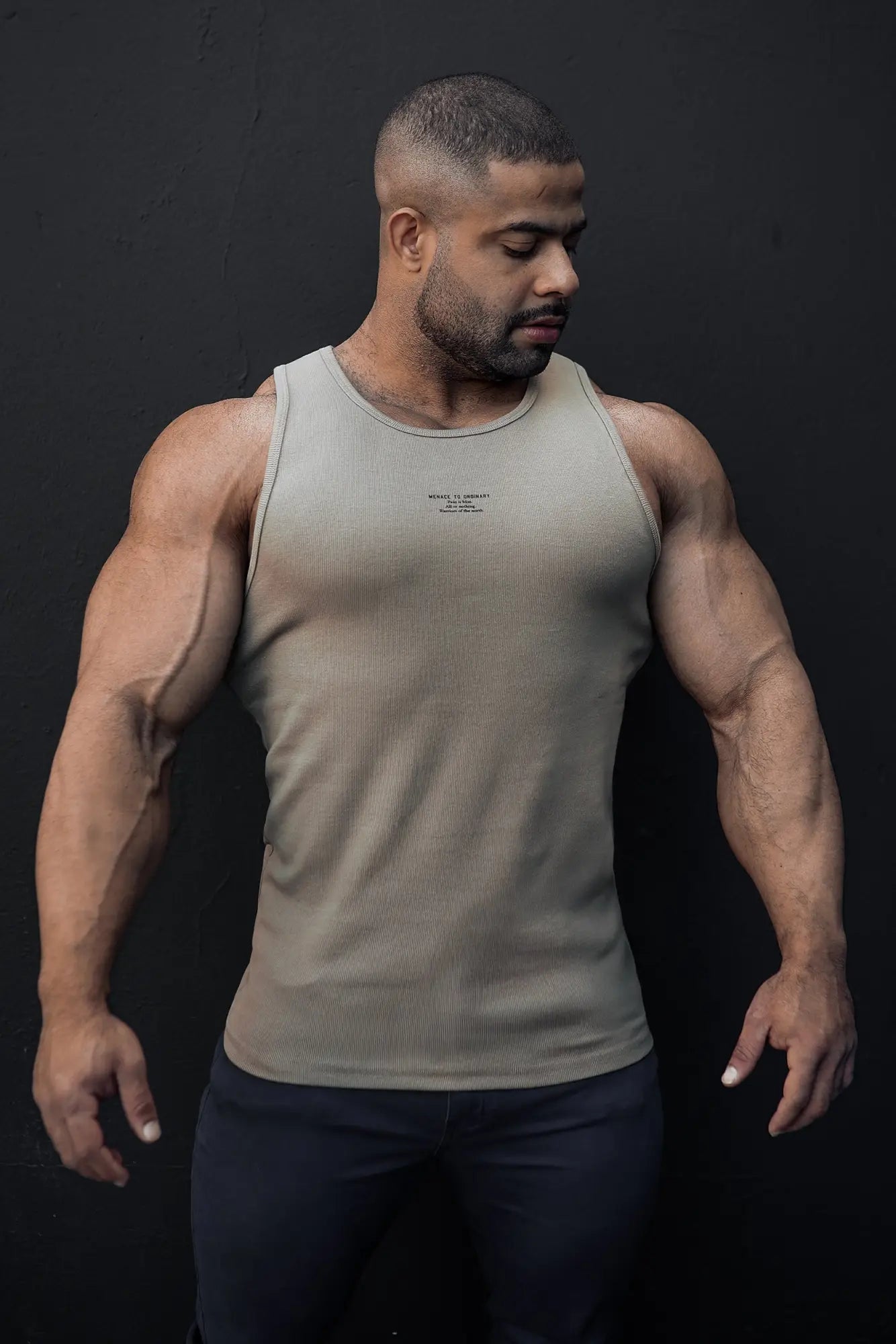 A sleek olive green ribbed muscle tank top with a subtle logo on the chest in khaki color