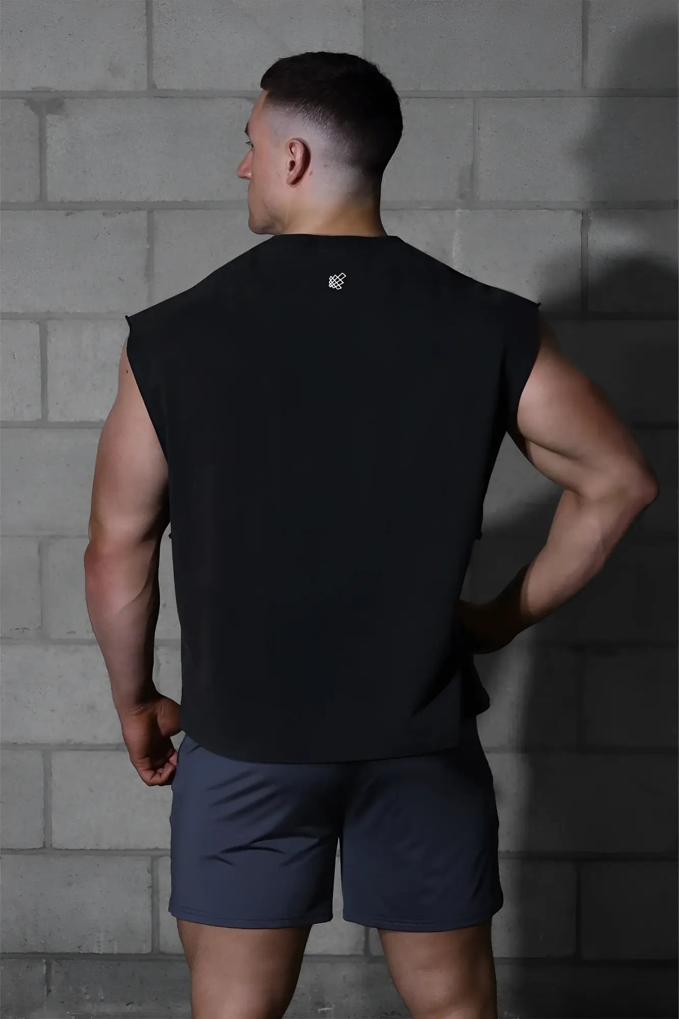 Black sleeveless athletic tank top by Jed North with box cut and small white logo on the back