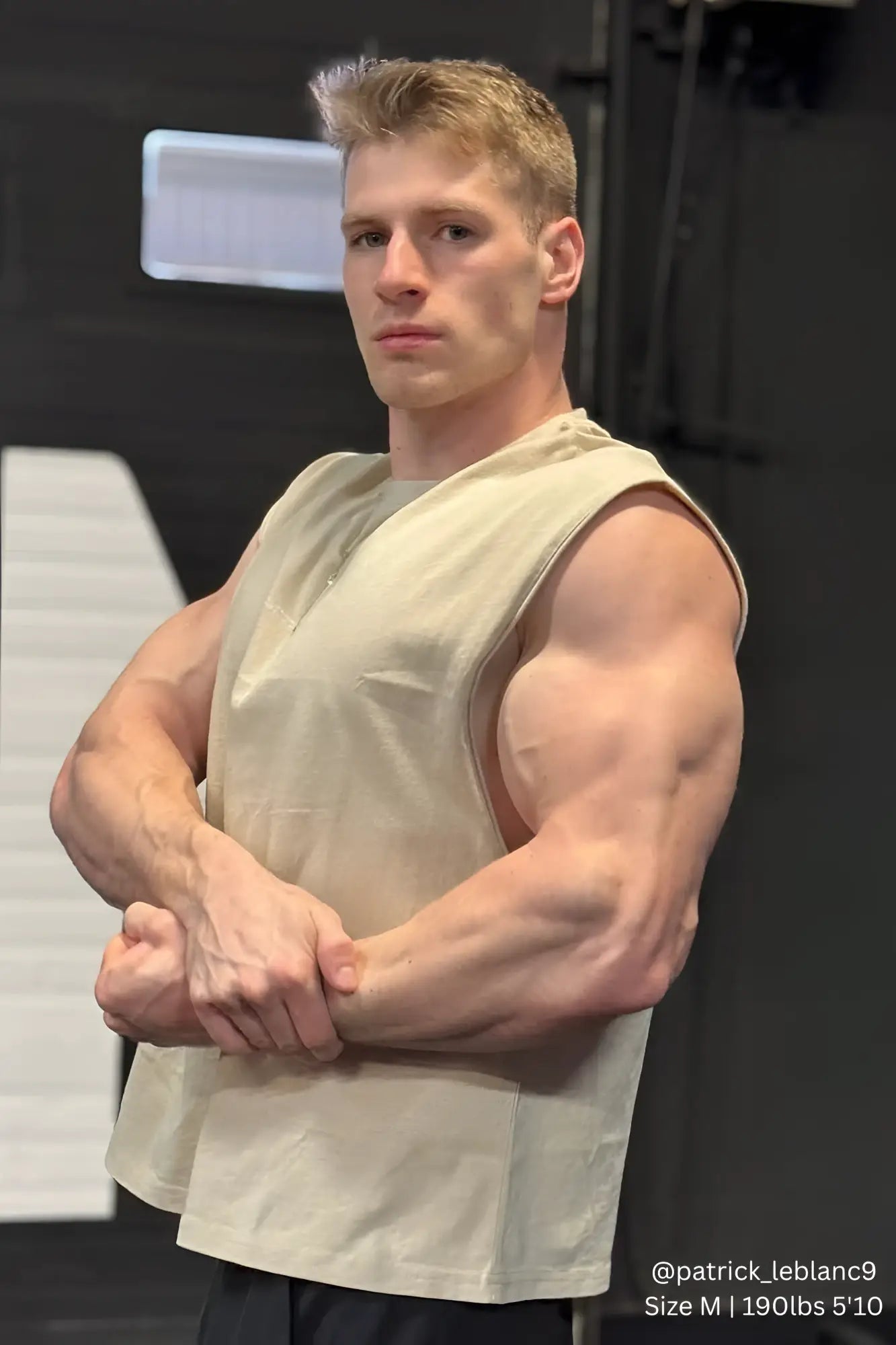 Beige sleeveless athletic tank top by Jed North with relaxed fit and subtle front pocket in light khaki color