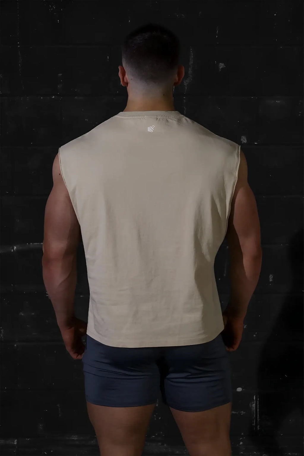 Beige jed north sleeveless box cut tank top with subtle logo at neckline perfect for muscle definition