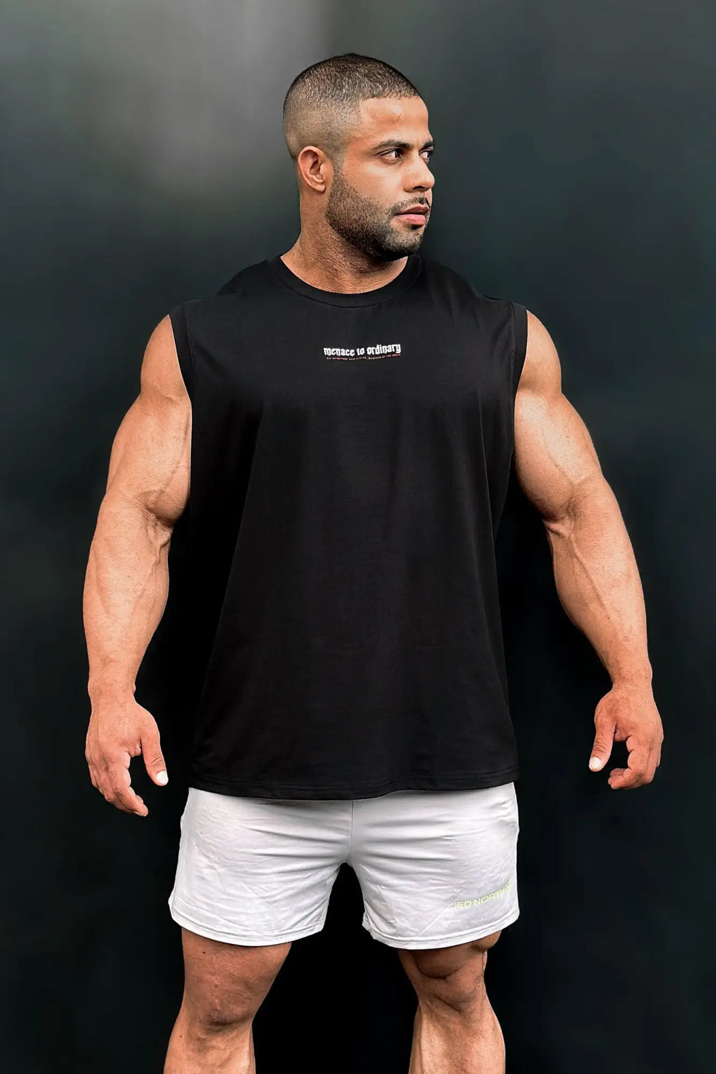 Black sleeveless athletic cotton muscle tee by Jed North with a small white logo on the chest for workout wear