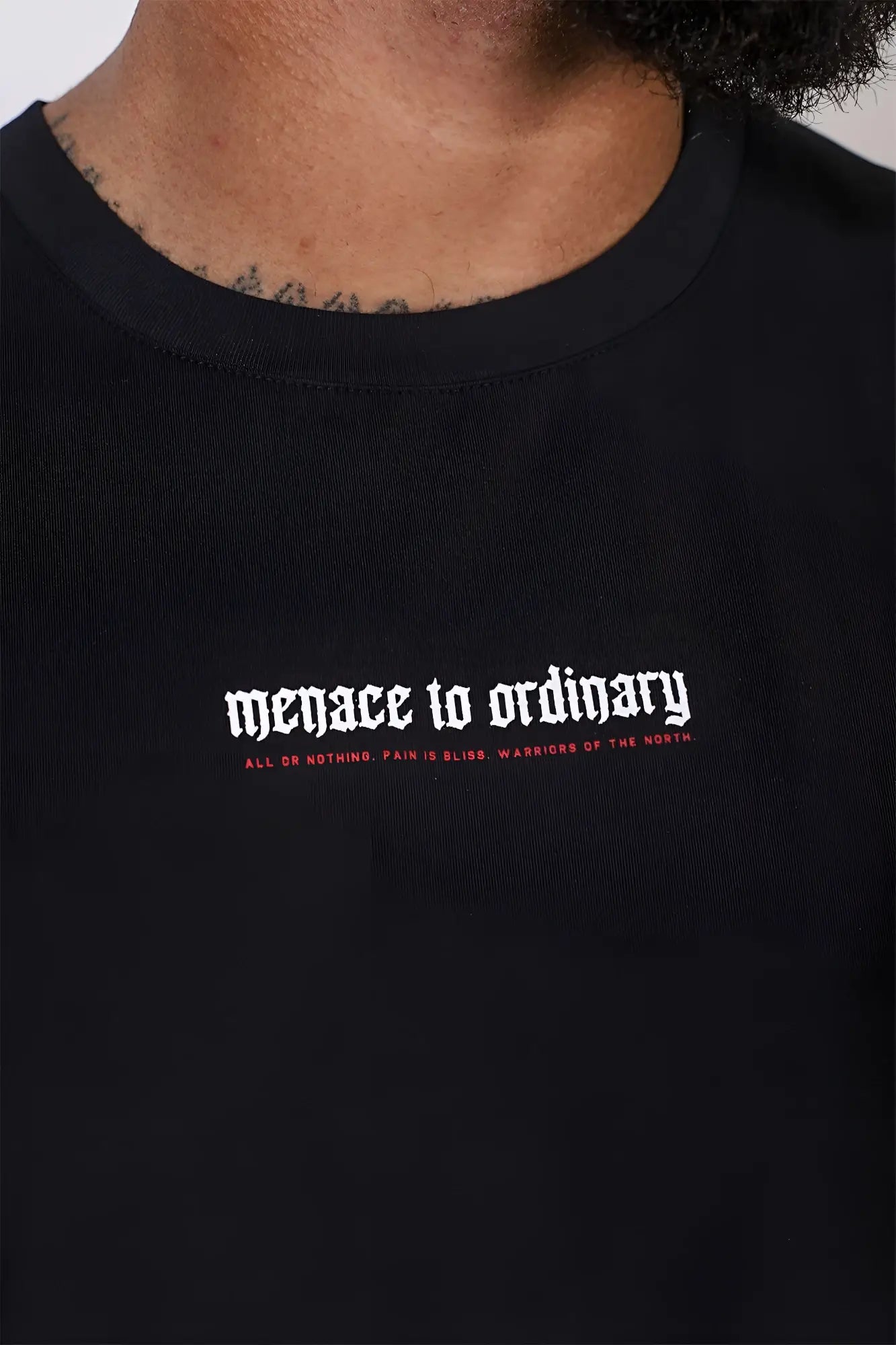 Black cotton Jed North sleeveless muscle tee with white and red gothic text menace to ordinary on chest