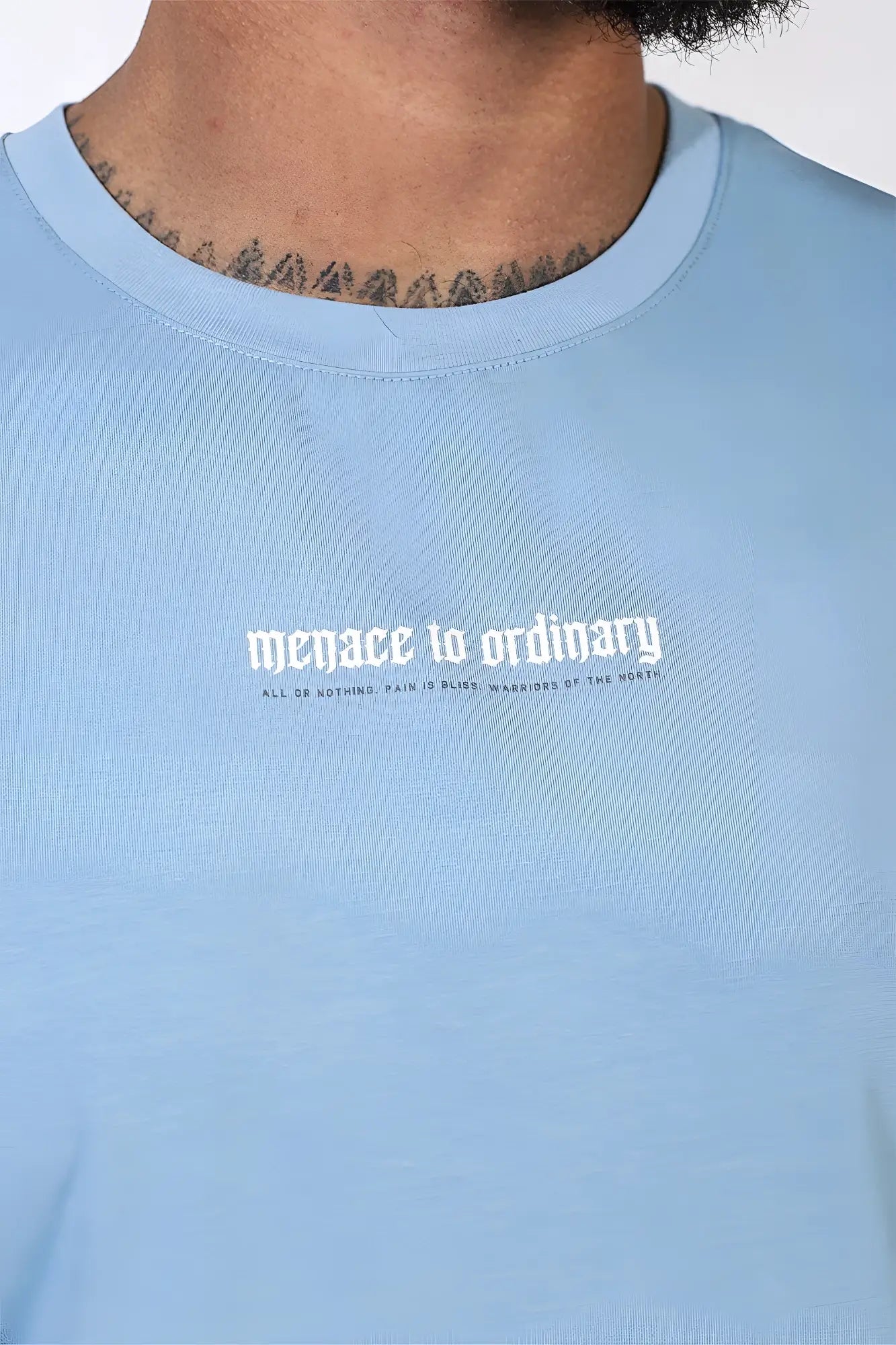 Jed North sleeveless muscle tee light blue with white gothic style menace to ordinary text on front