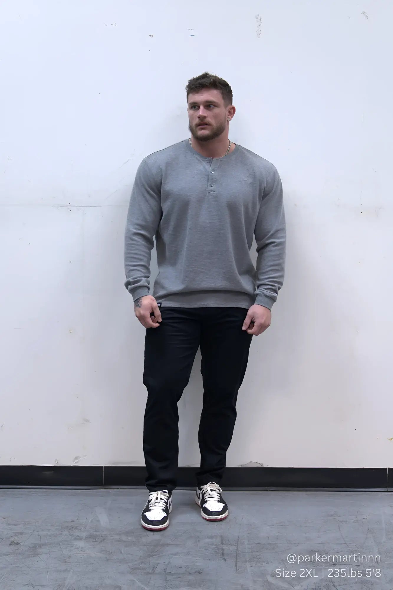Gray long-sleeved cotton henley shirt paired with smart casual black chino pants for versatile everyday wear