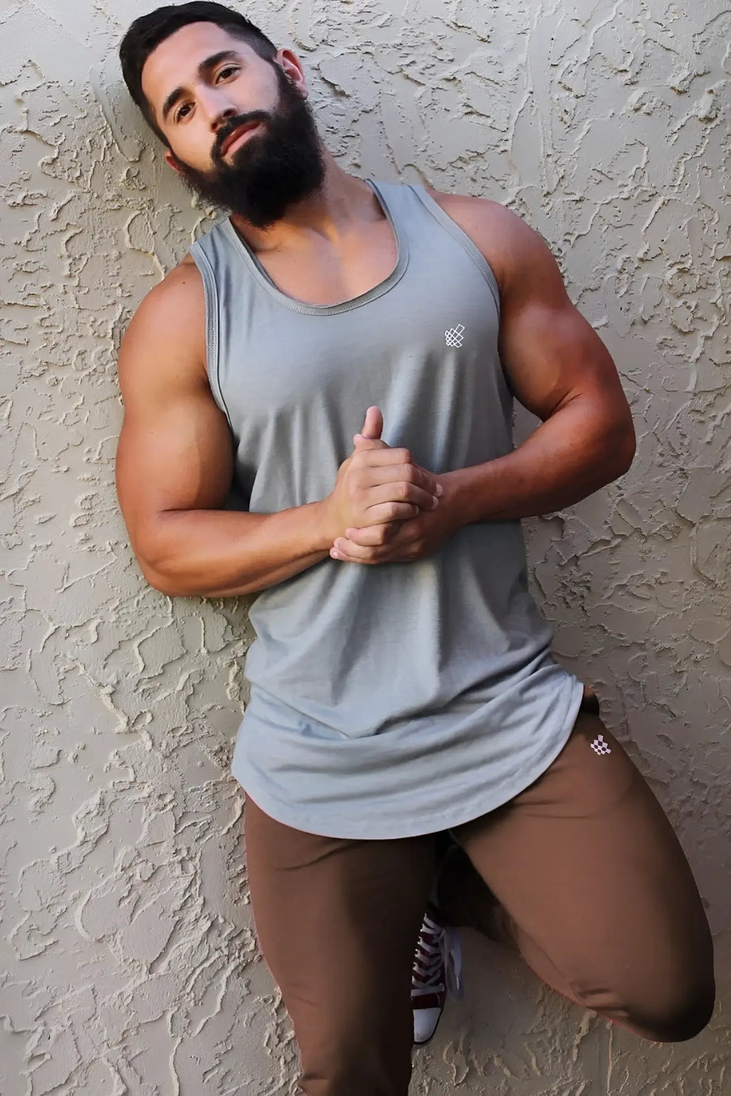 Gray muscle tank top with a small white logo on the chest paired with jed north spirit joggers in brown