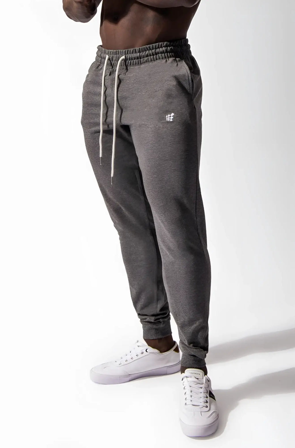 Dark gray heathered spirit joggers with white drawstrings and embroidered logo on left thigh in comfortable fabric
