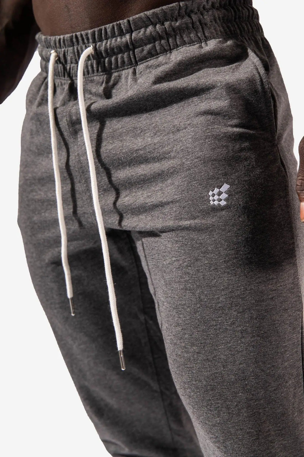 Spirit joggers dark gray heathered sweatpants with white drawstrings and a checkered logo on the thigh