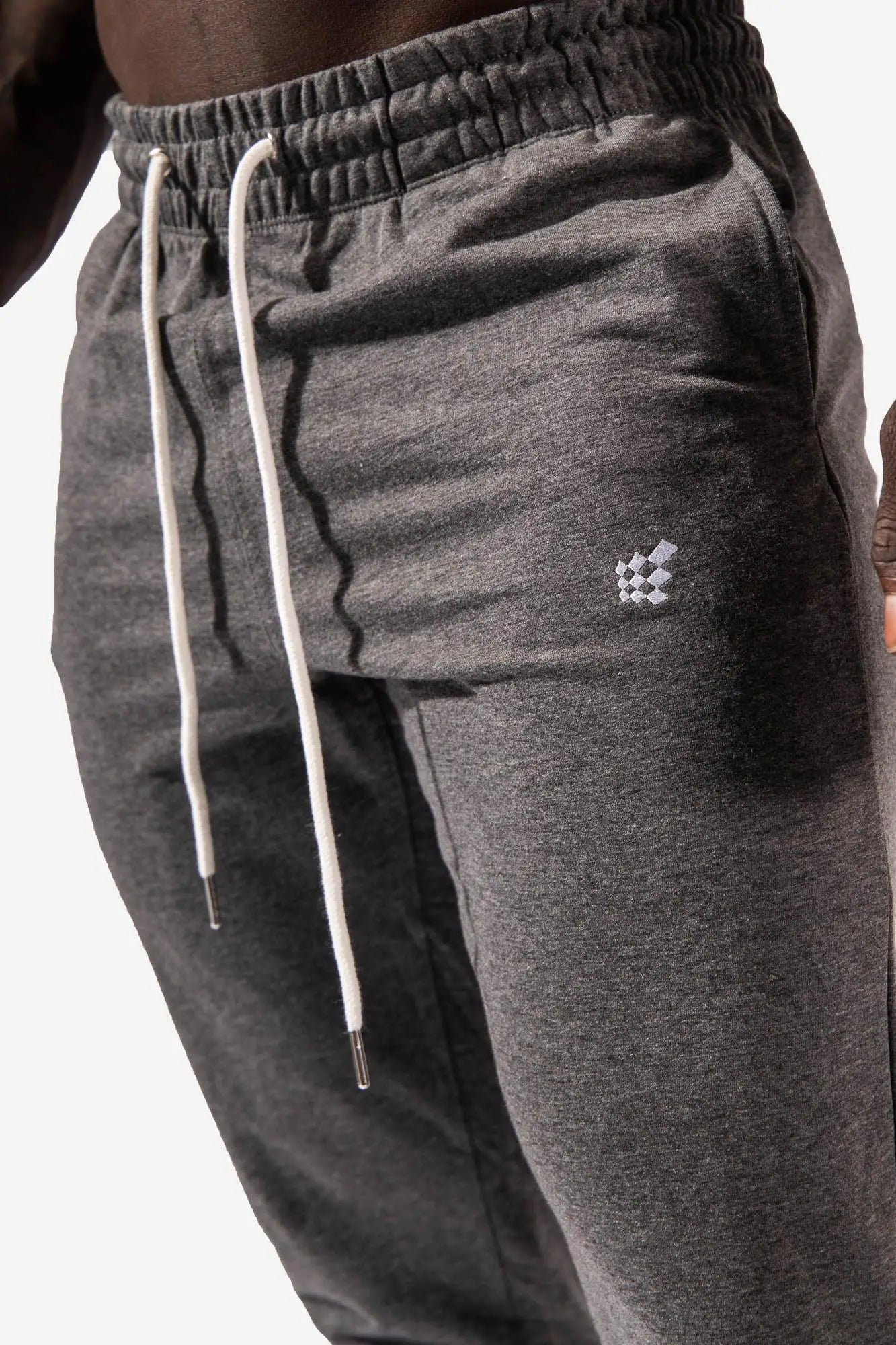 Spirit joggers dark gray heathered sweatpants with white drawstrings and a checkered logo on the thigh